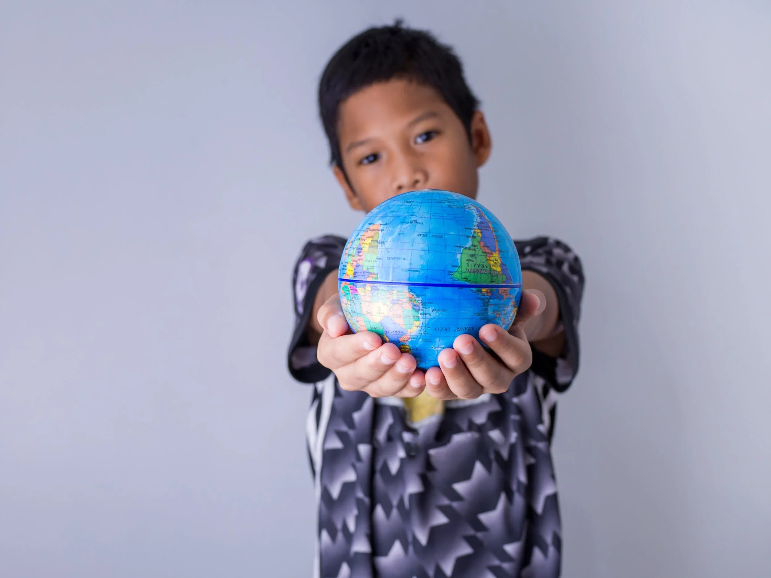 vecteezy_boy-holding-a-globe-stand-out-in-front_3400161.webp