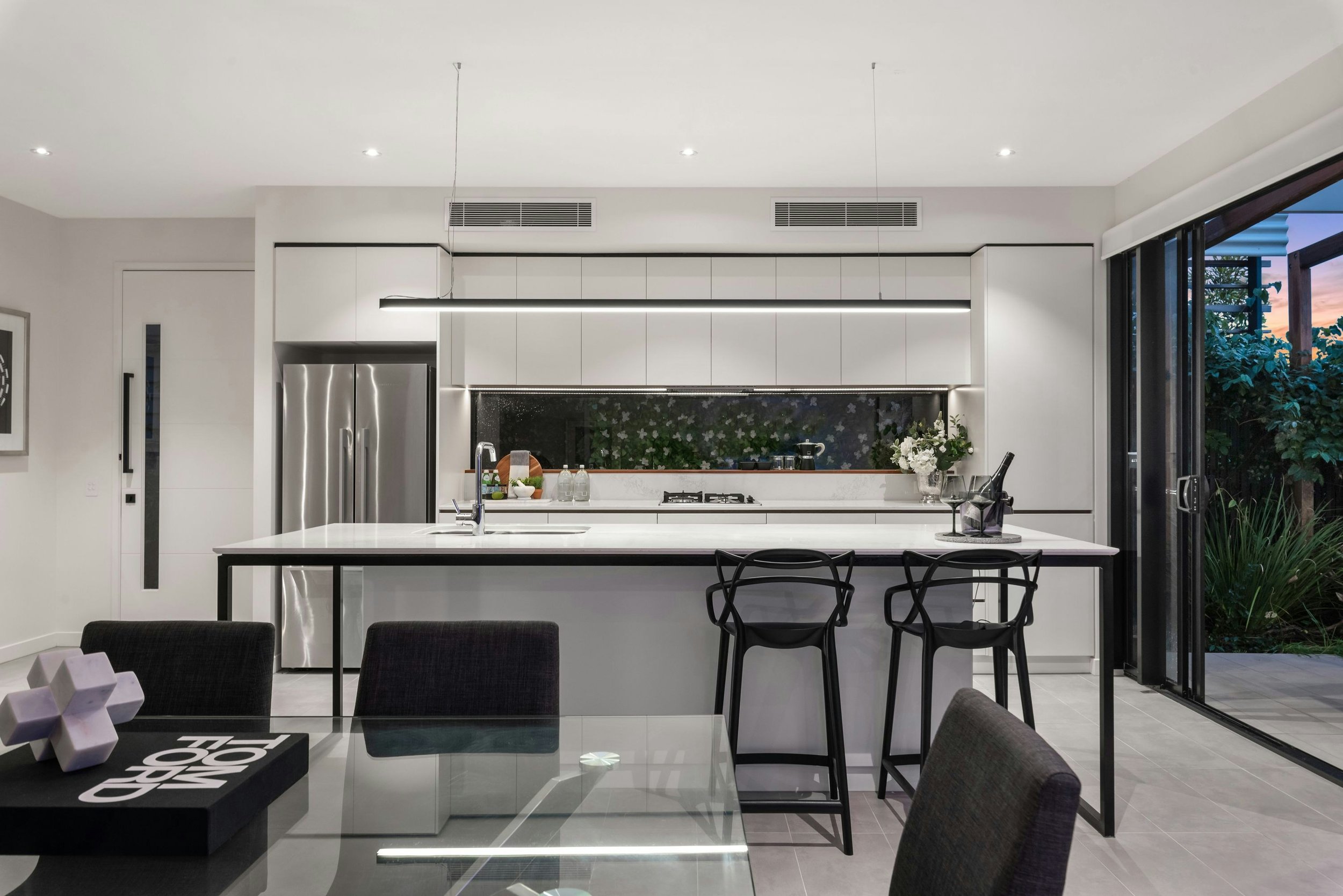 New build kitchen with beautiful modern slimline black pendant lighting illuminating the island bench