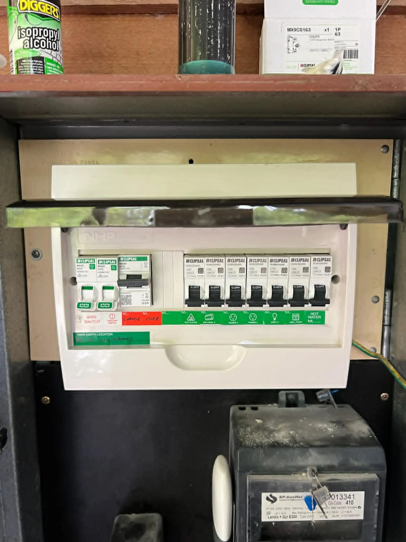 Electrical circuit breaker box with switches, labels, and warning signs, mounted on a black metal stand.