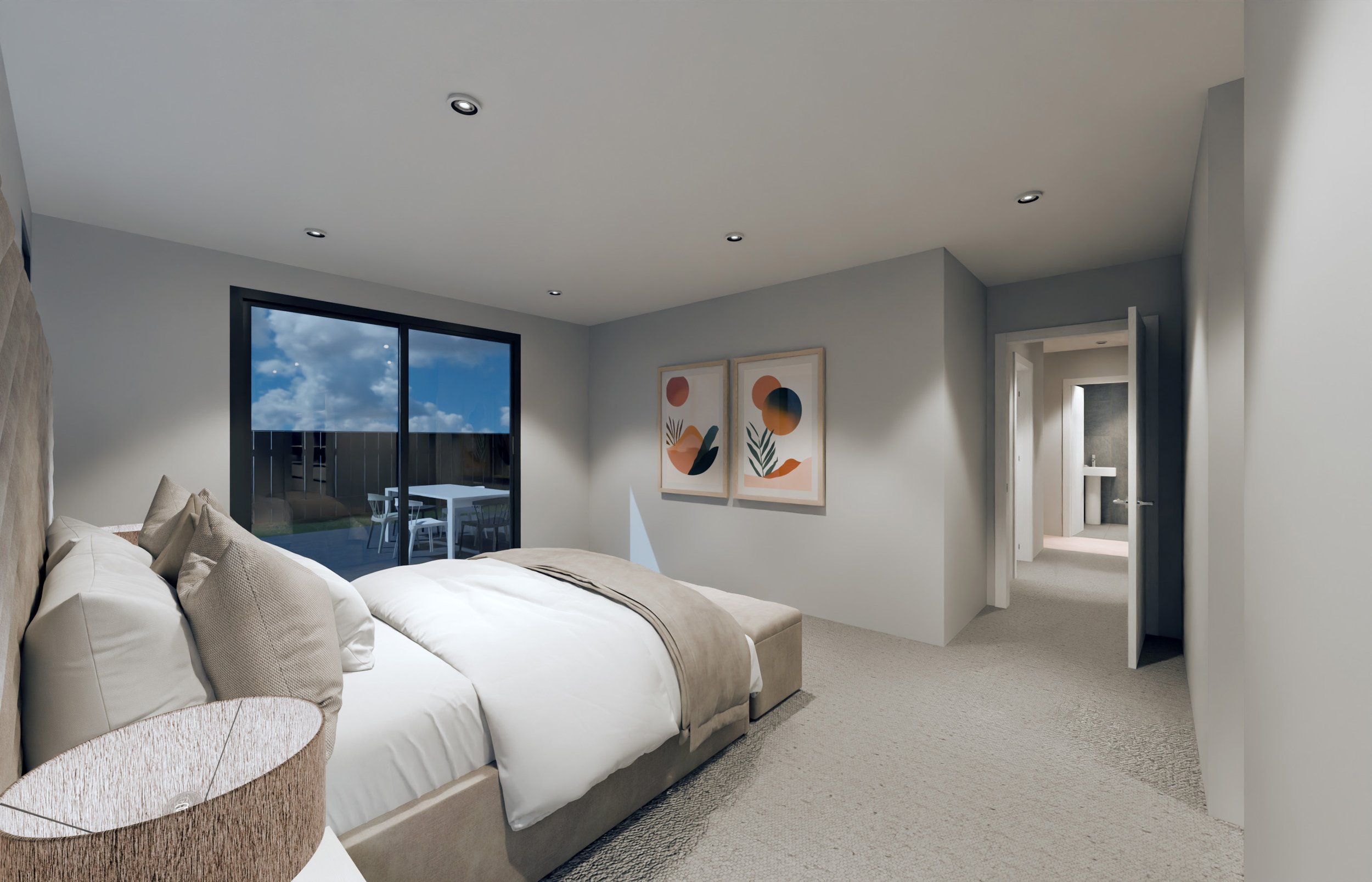 Modern bedroom with a large bed, beige headboard, beige bedding, and pillows. A sliding glass door leads to a balcony with outdoor dining furniture. Wall art with abstract shapes hangs above the bed. Recessed ceiling lights and a view of a hallway wi