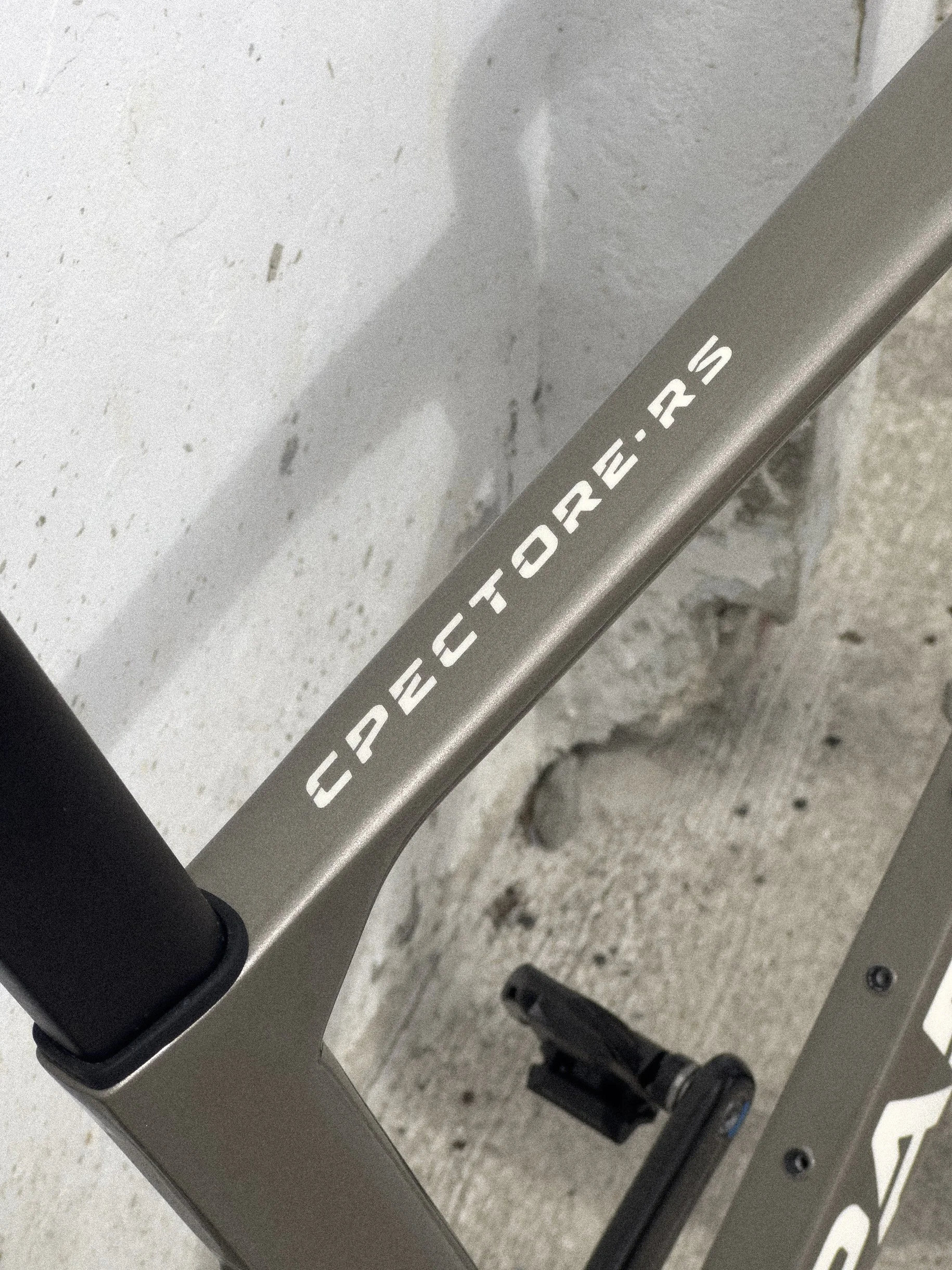 Close-up of a PARENTESI bike with white text, with a concrete wall in the background.