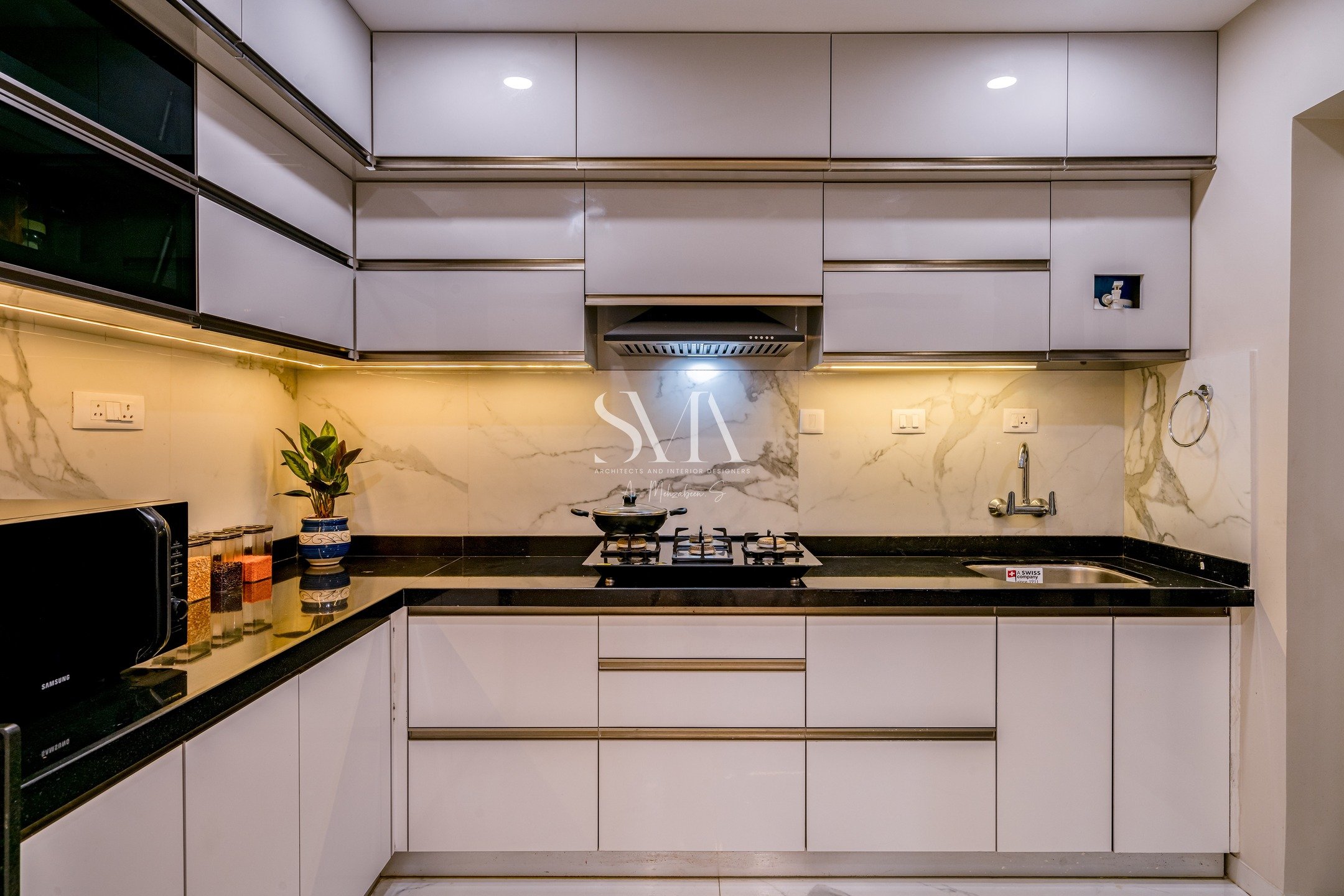 Sleek. Stylish. Functional. ✨ This stunning kitchen by SMA Architects redefines modern living. Explore the refined elegance of our Baner project.
&bull; Sleek &amp; Streamlined Design: The predominantly white cabinetry creates a bright, expansive fee