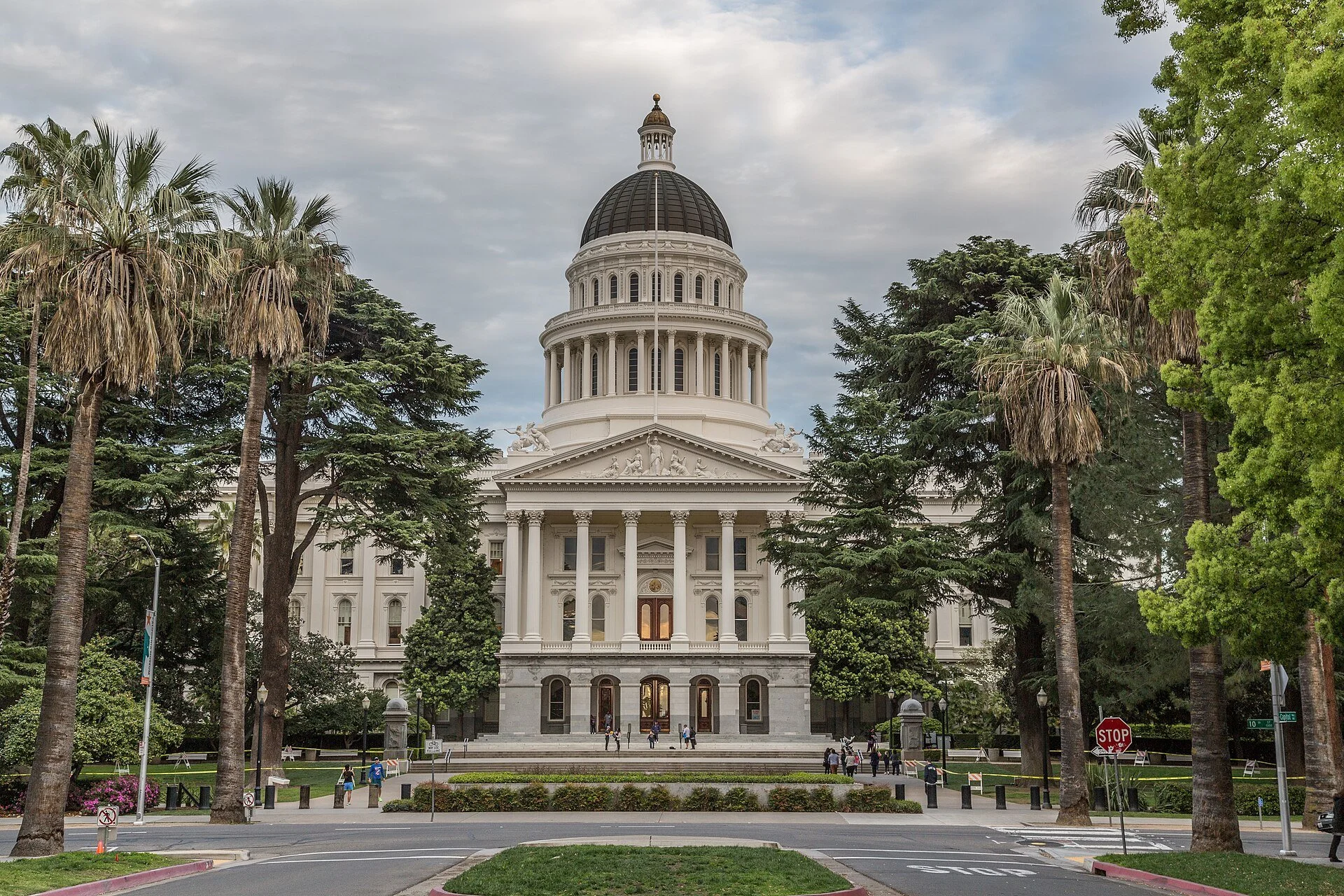 The California State Capitol in Sacramento, a white domed building at the end of a palm-lined mall.