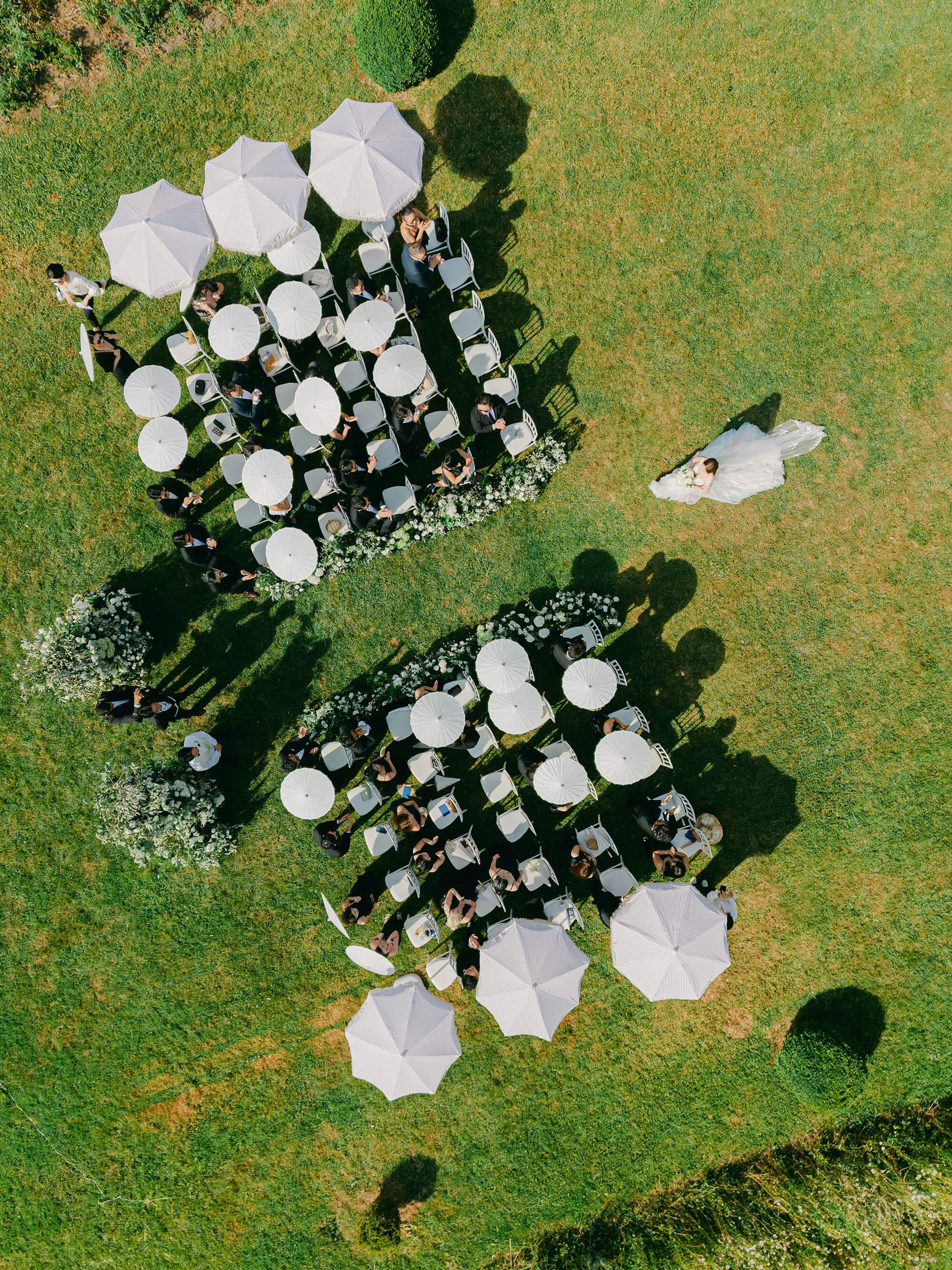 Aerial view of the outdoor wedding ceremony and floral aisle in the château park