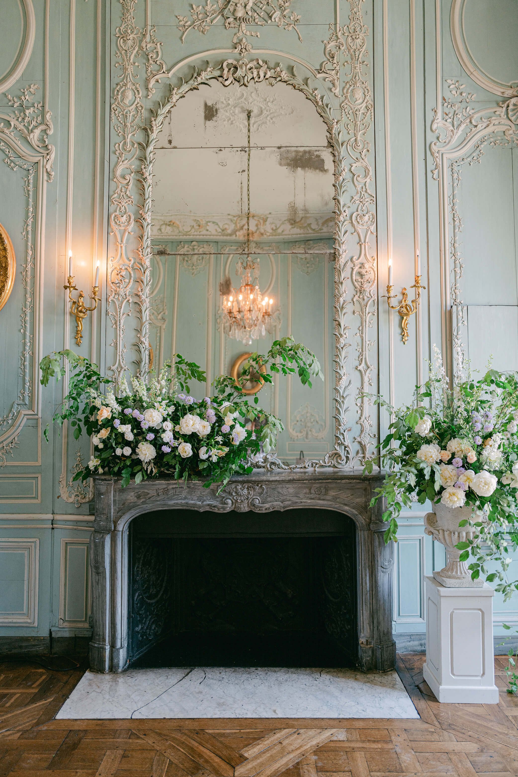 Garden-inspired floral installation arranged around a historic fireplace