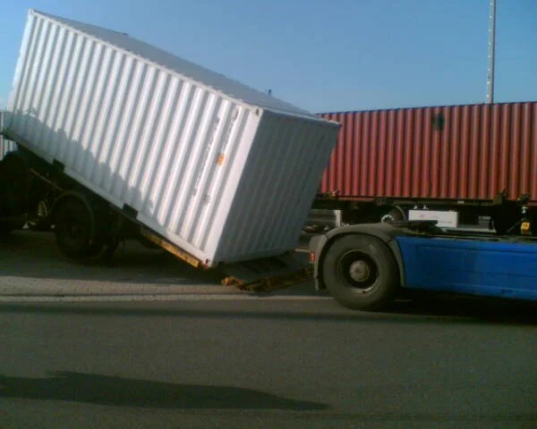 Ein LKW hat einen Container auf der Straße, der umgekippt ist.