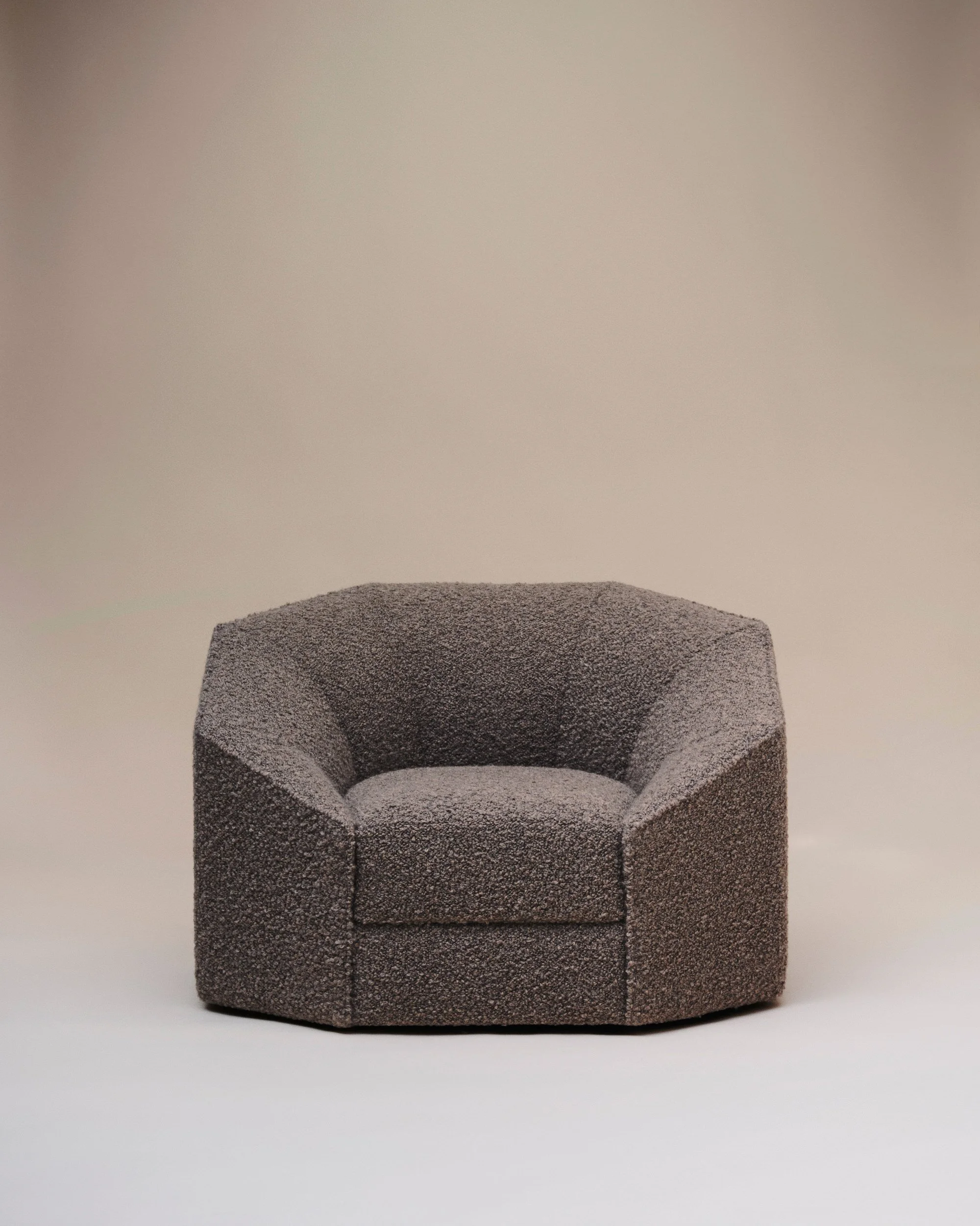 Fauteuil moderne en tissu gris foncé dans un décor minimaliste