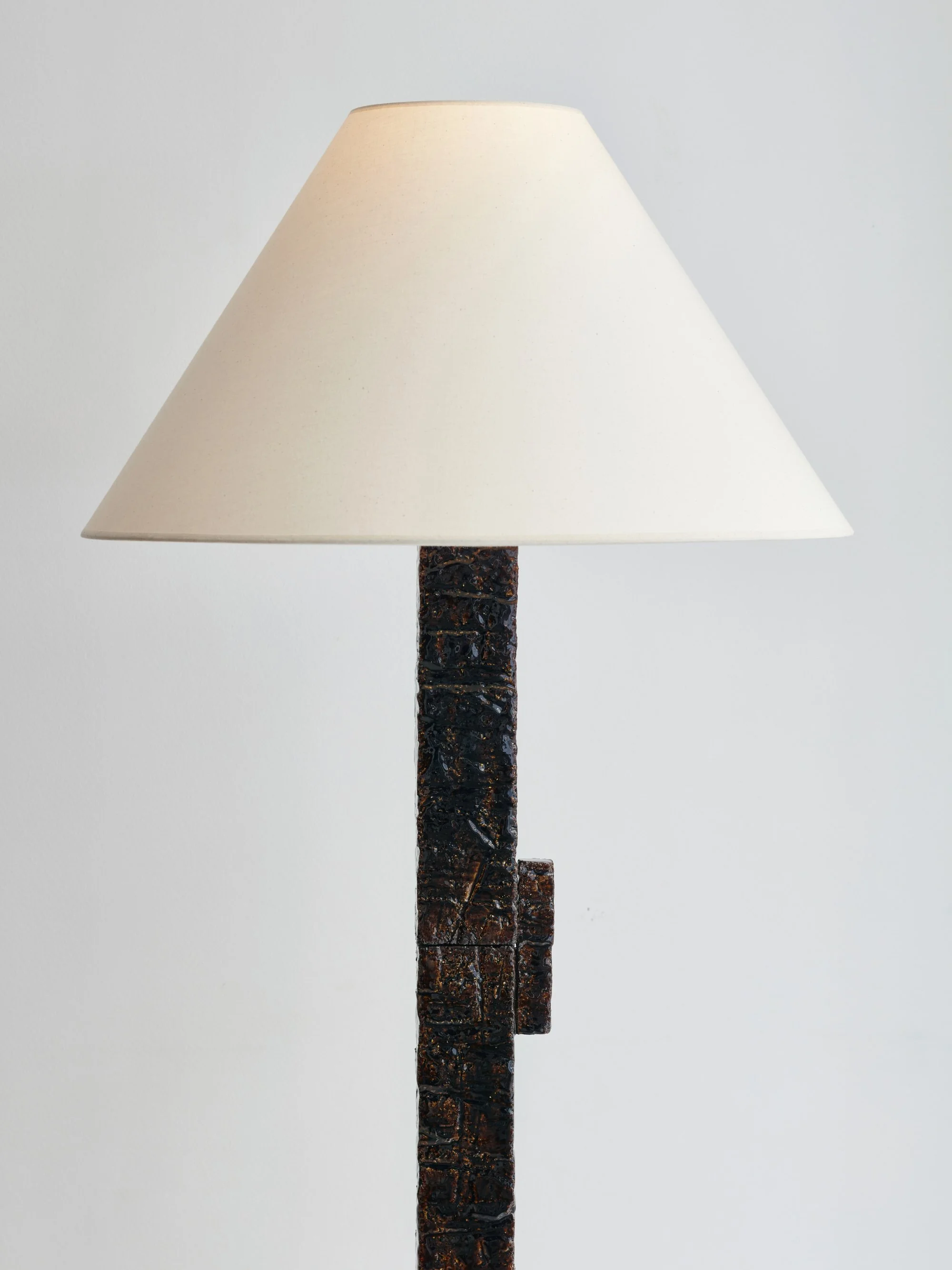 Lampe de chevet avec un abat-jour blanc et une base en bois foncé.