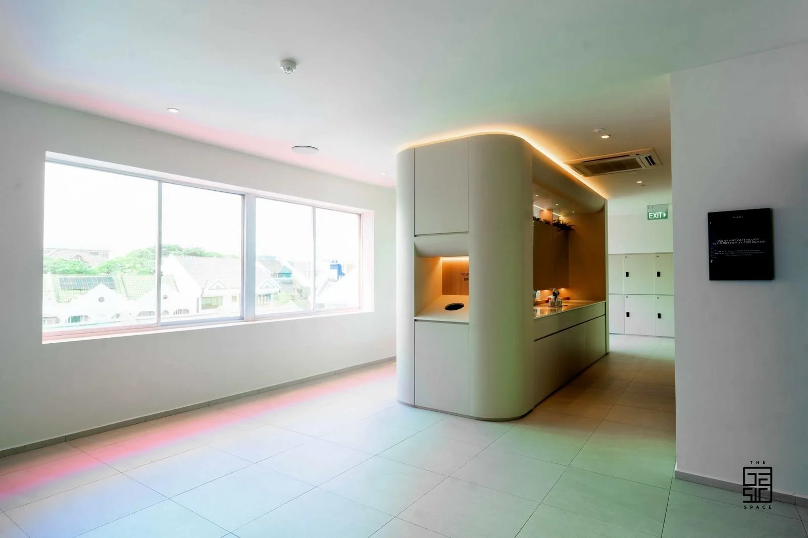 Modern, minimalistic kitchen with large window, white walls, and light-colored flooring.