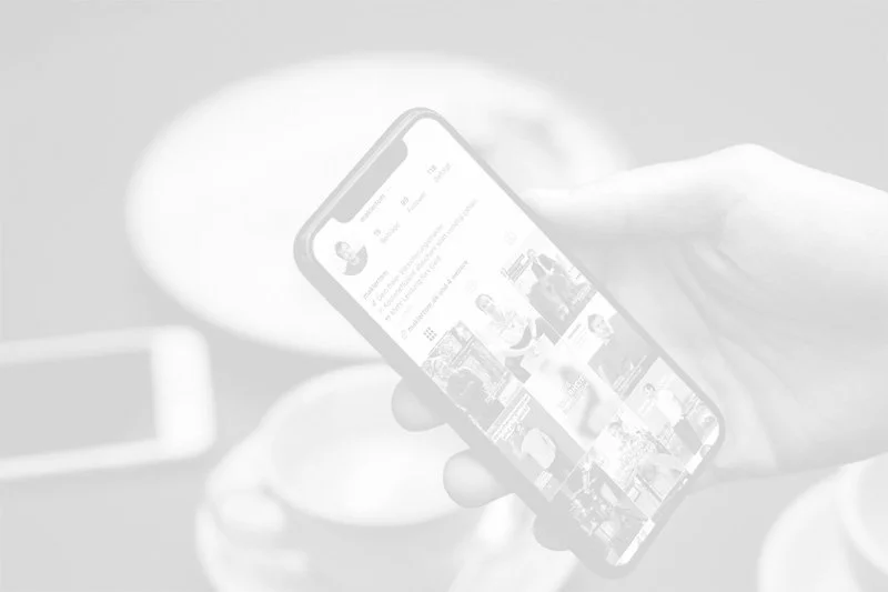 iPhone in einer Hand mit dem Instagram Feed von maklertom