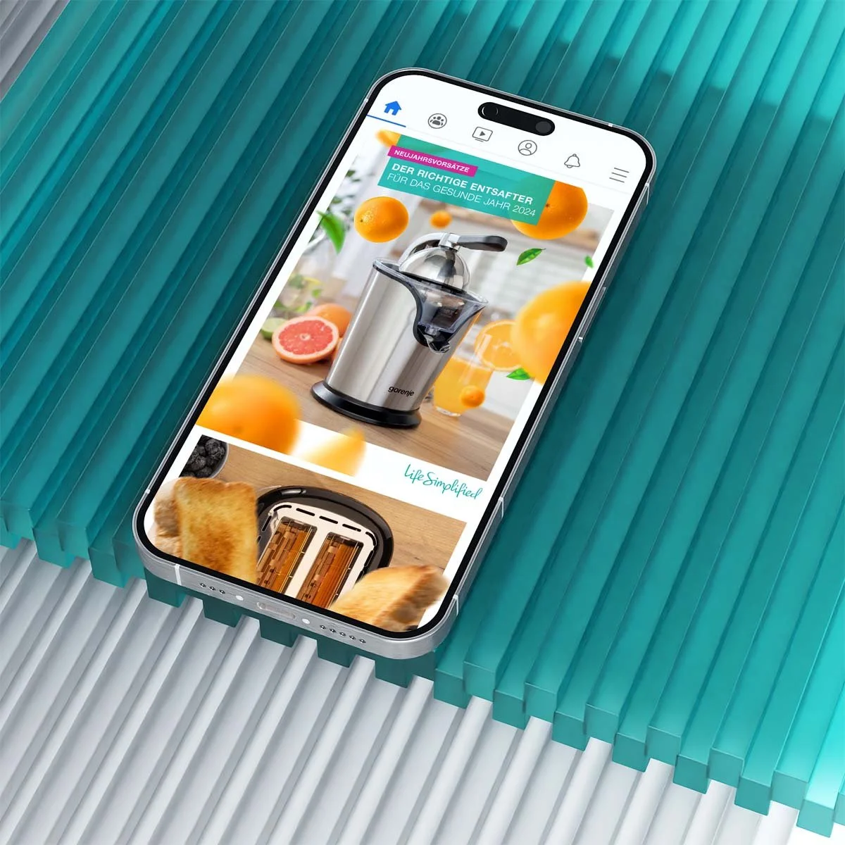 Mockup eines iPhones mit einem Facebook Post von Gorenje Deutschland. Das iPhone liegt auf türkisem Plastik