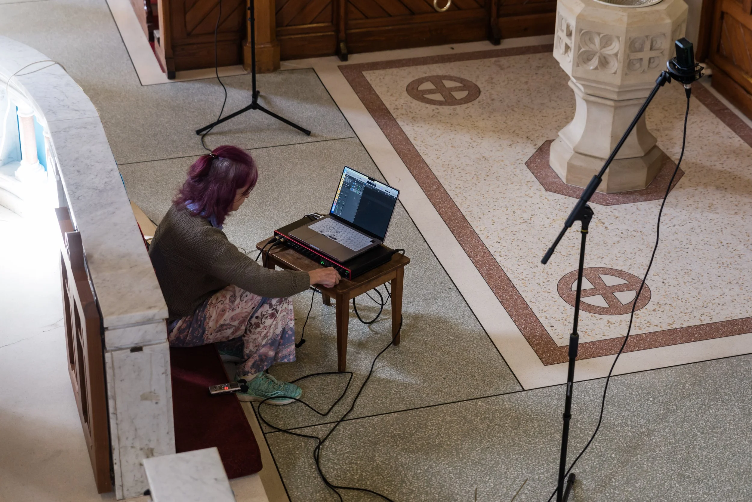 Photo of Sara Walmsley working on laptop in an installation project