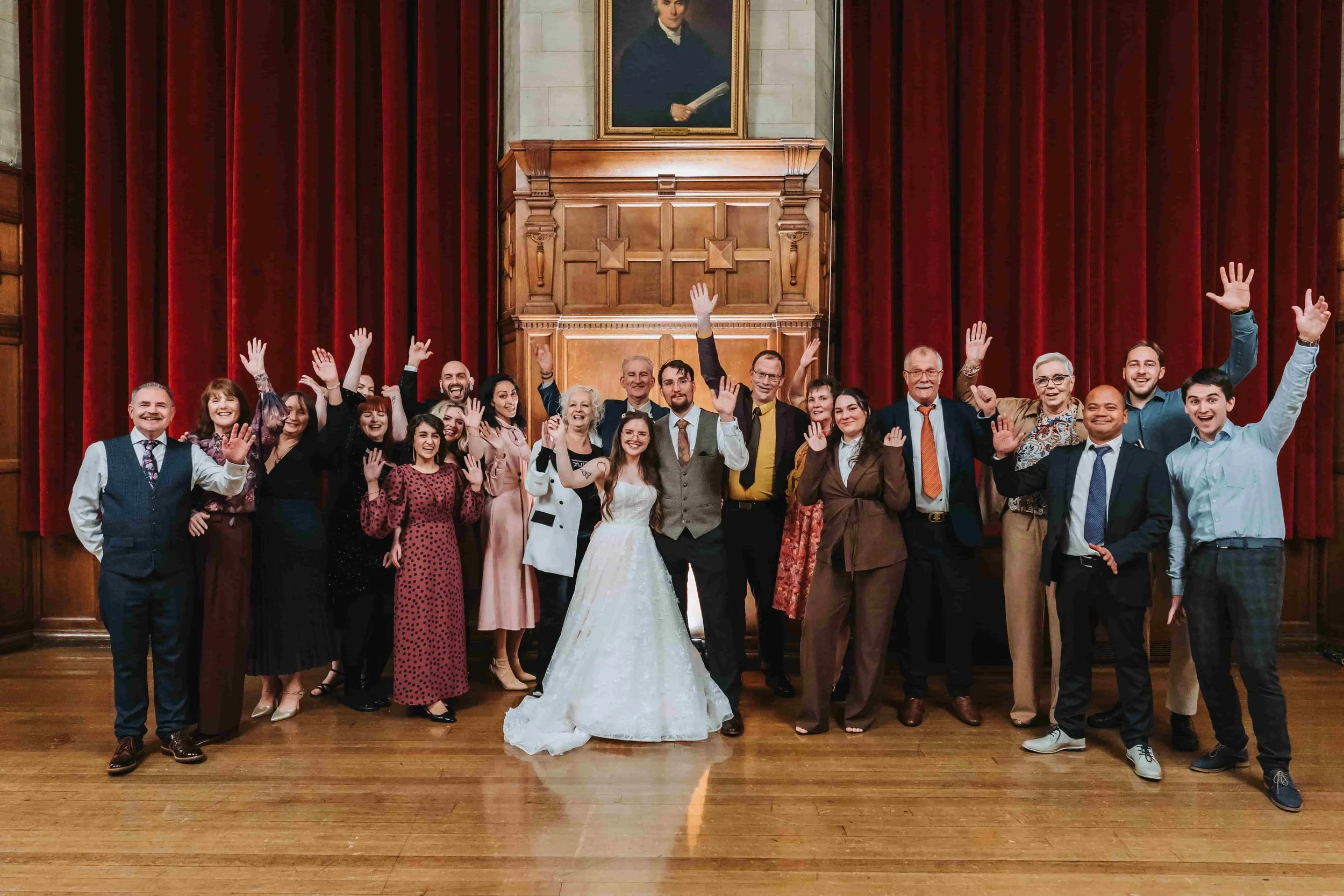 Wedding group photo in front of the fireplace in the Assembly Room at Oxford Town Hall