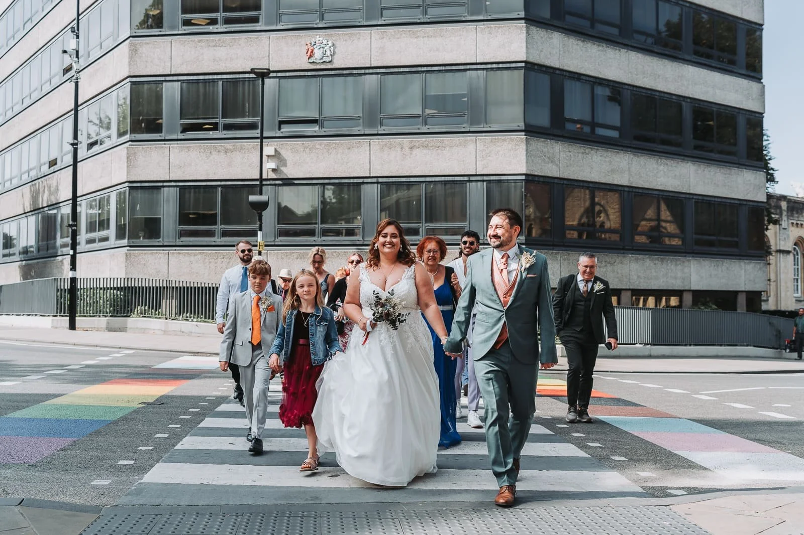 Wedding party walking over LGBTQ+ crossing after ceremony at Oxford registry office