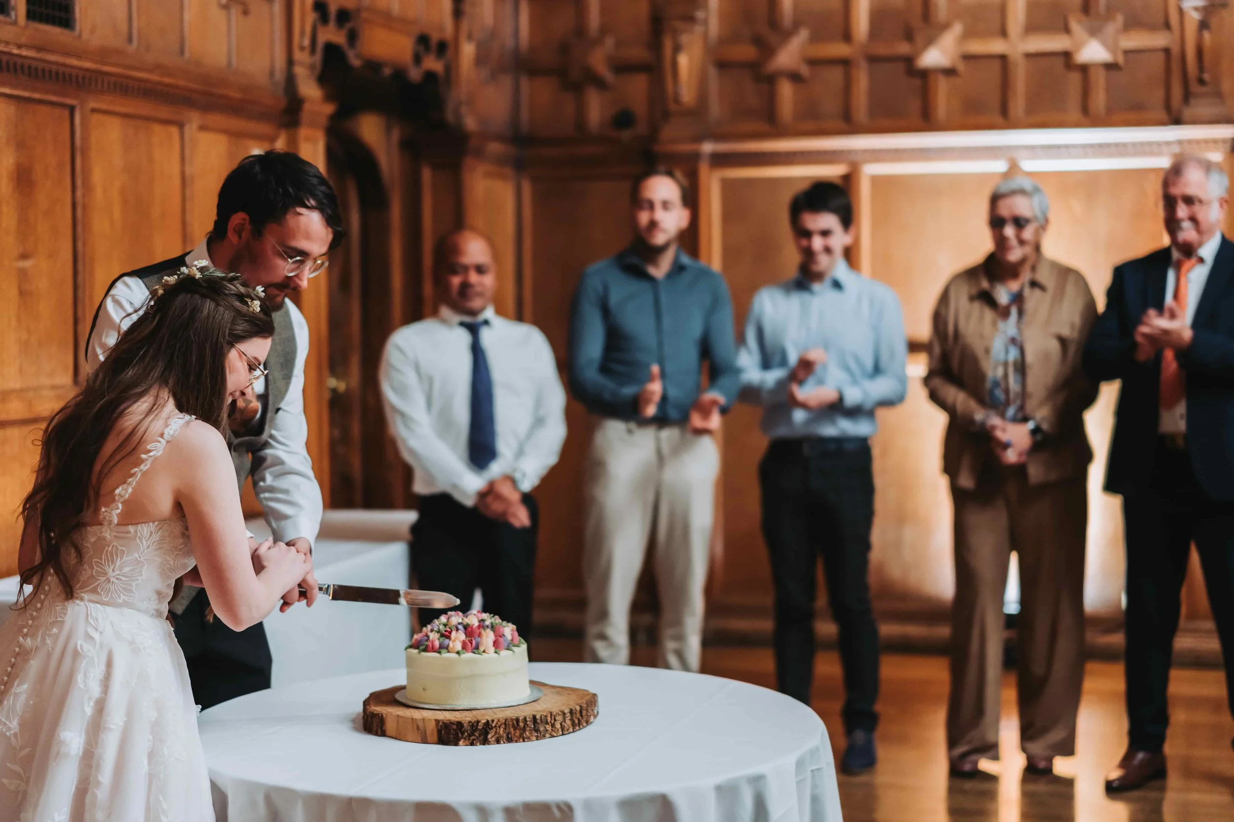 Bride and groom cutting their wedding cake in the Assembly Room at Oxford Town Hall