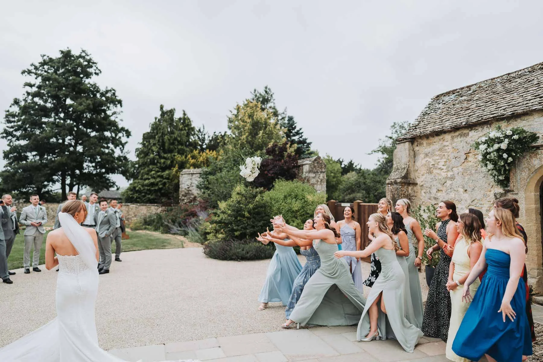 bride-tosses-bouquet-bridesmaids-oxfordshire-caswell-house.jpg