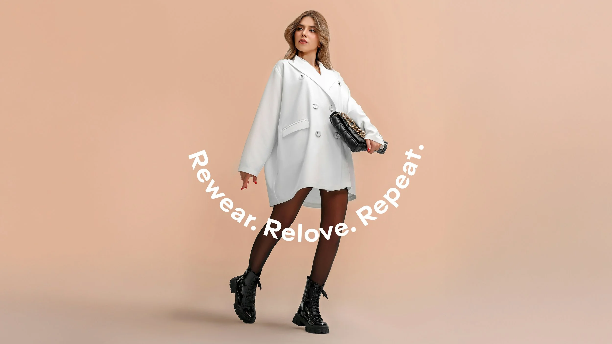 A young woman wearing a white oversized double-breasted blazer, sheer black tights, and black combat boots, holding a black quilted purse with a chain strap. The background is a plain beige color, and white text curved around her reads: "Revwear. Relove. Repeat.".