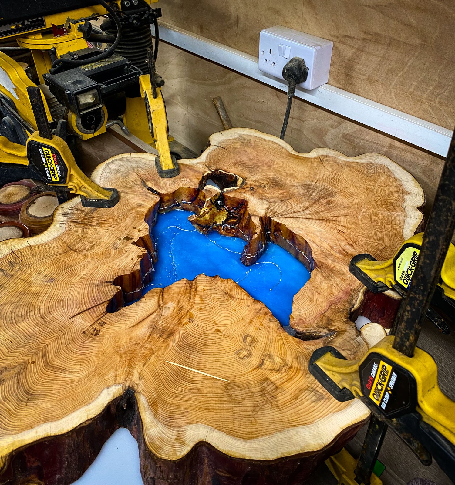  This live edge yew tree slice is clamped firmly to a base board before resin is poured into the central ‘lake’.  