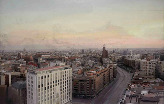 Vista panorámica de la ciudad con edificios y calles, al atardecer.