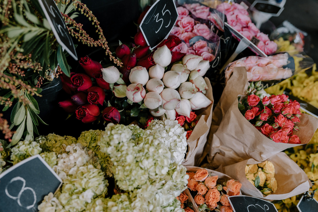 Variety of bouquets and bunches of colorful flowers including roses, peonies, and hydrangeas, displayed at South Melbourne Market.