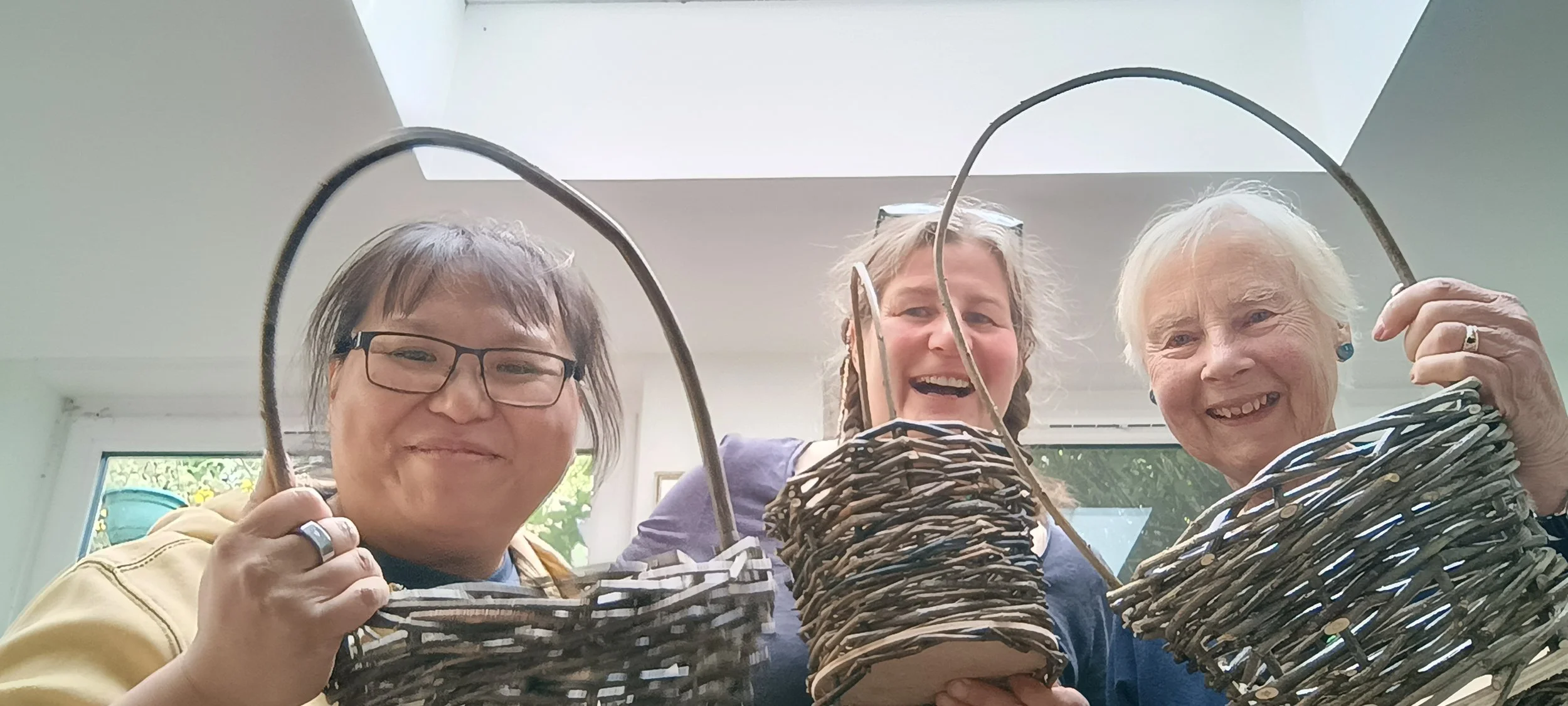 three attendees with their foraging baskets made on an Away with Willow workshop Edinburgh