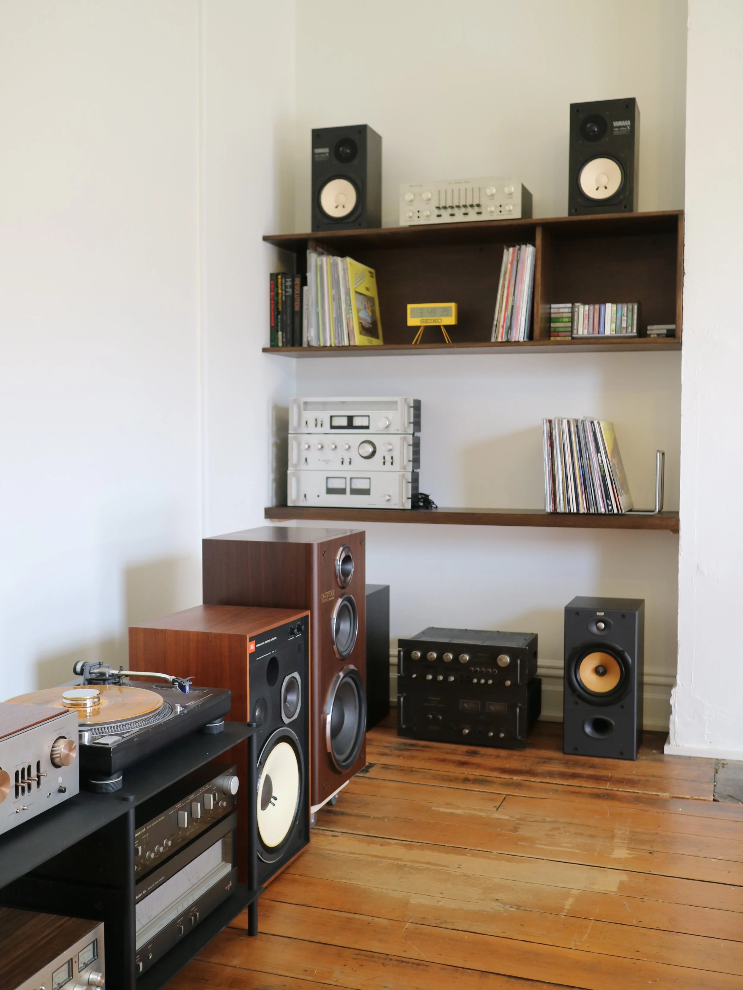 A room with vintage audio equipment including speakers, turntables, and records.