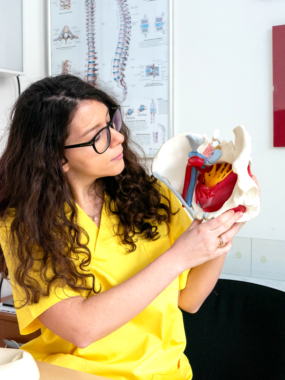 Lidia Mancazzo che mostra un modellino del bacino per illustrare temi relativi alla fisioterapia del pavimento pelvico.