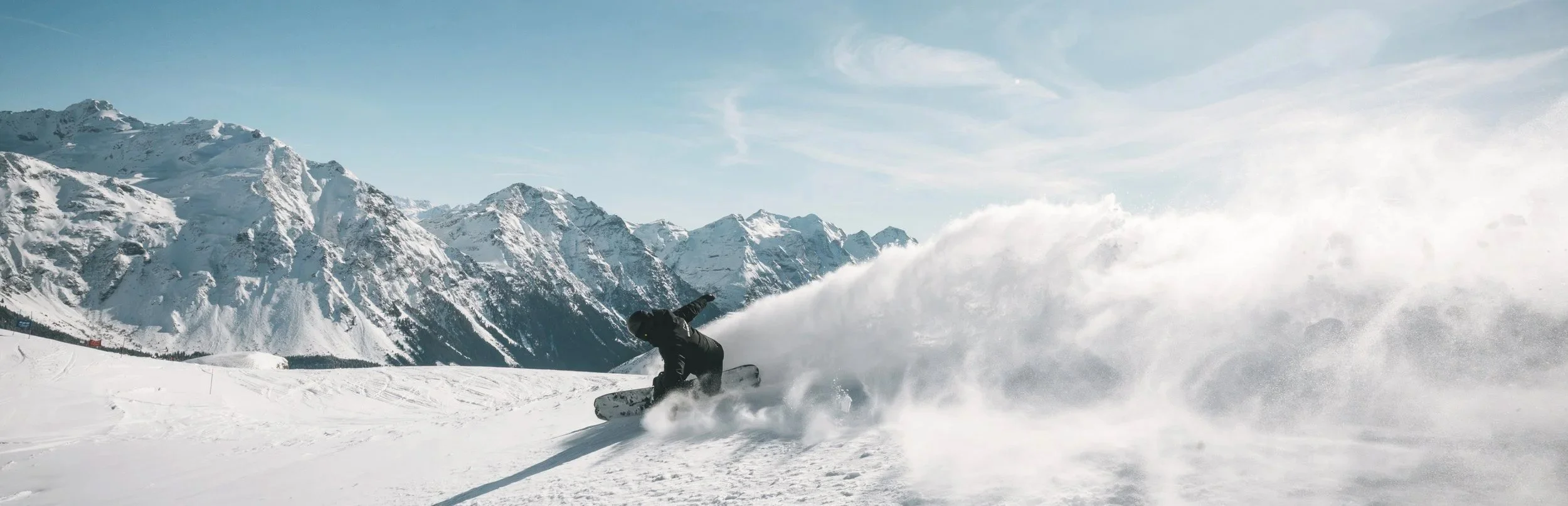 Scena invernale a San Bernardino con uno snowboarder sulle montagne innevate.