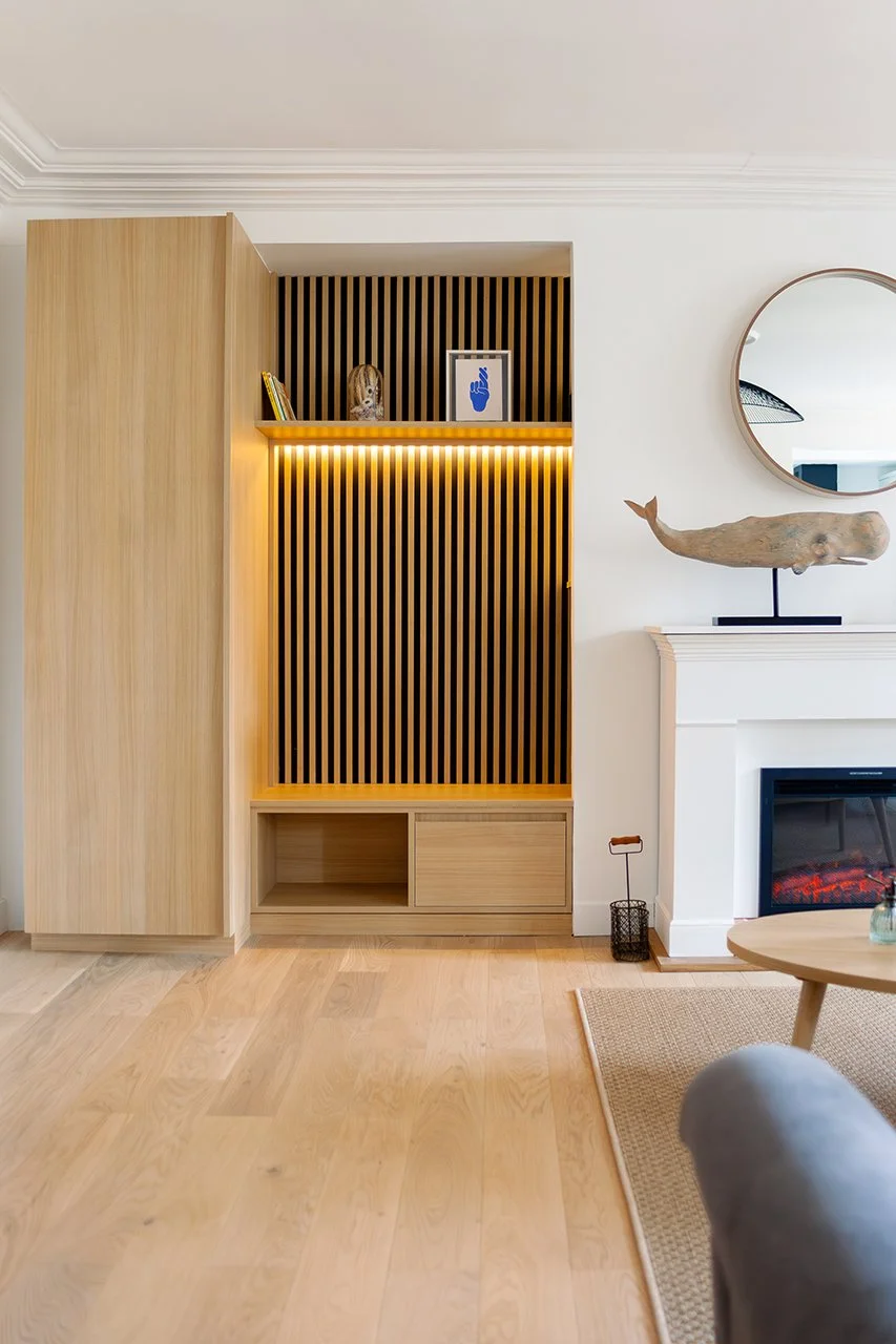 le chêne du meuble d'entrée sur-mesure fait écho au parquet qui recouvre l'ensemble du séjour et lui donne une ambiance chaleureuse.