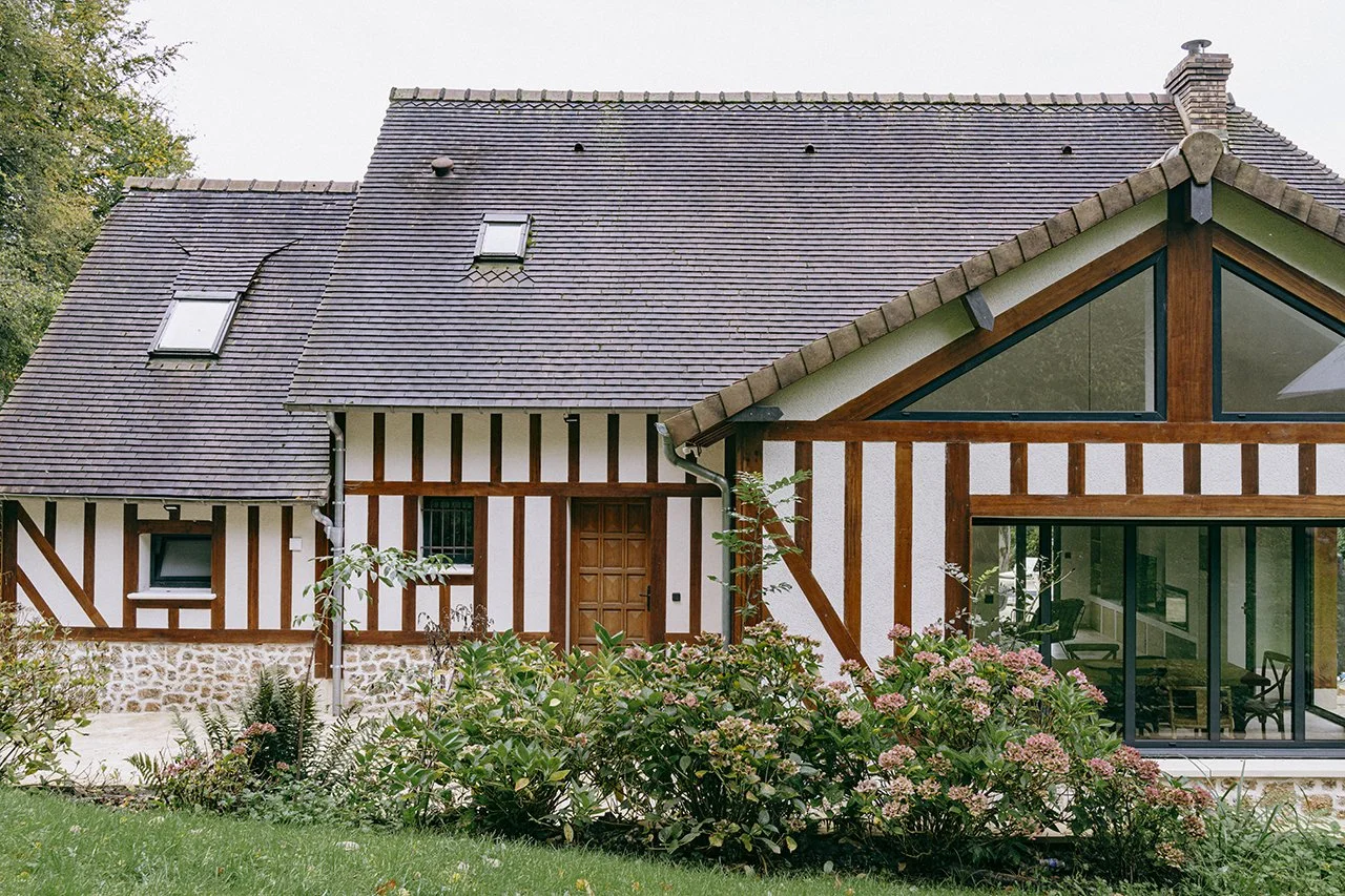 la façade arrière de la maison est recouverte de colombages et d'un sousbassement en pierre