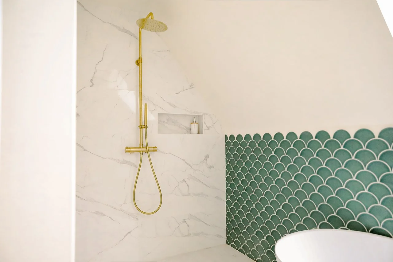 la faïence bleue en écaille de poisson contraste avec le carrelage et la faïence marbre de la douche.