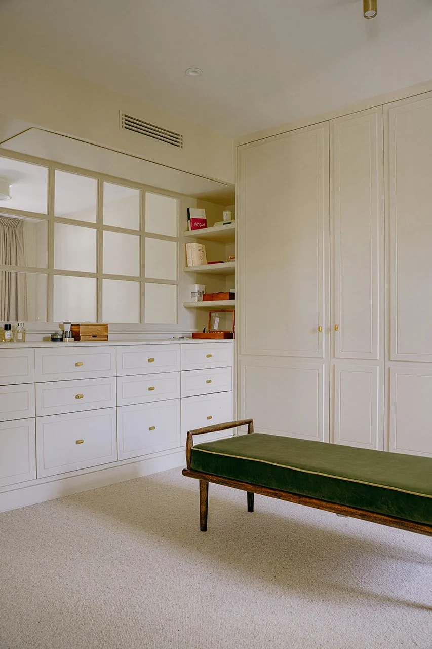 un grand dressing sur mesure a été déssiné . l'ensemble mouluré est peint en beige, au sol une moquette vient complèter l'ensemble.