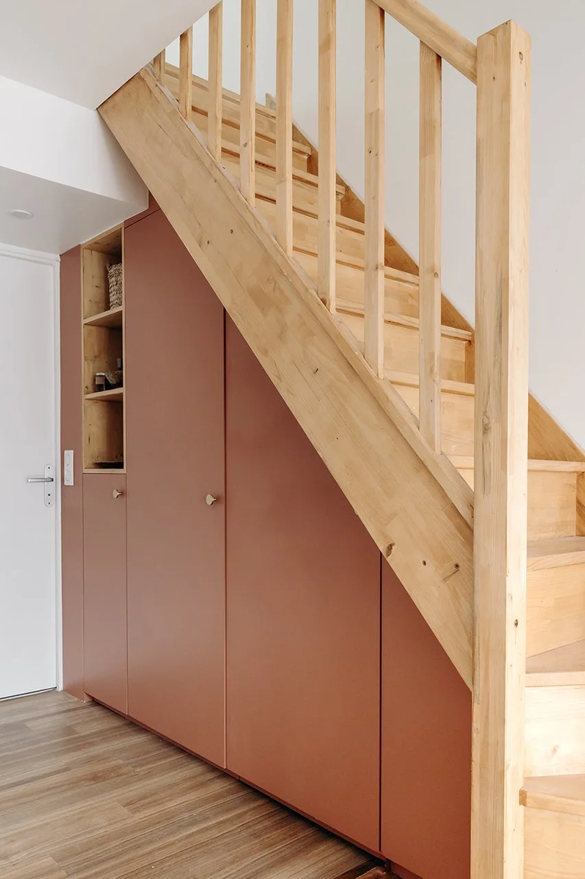 la partie sous l'escalier a été utilisée pour du rangement sur mesure afin d'optimiser cette entrée d'appartement