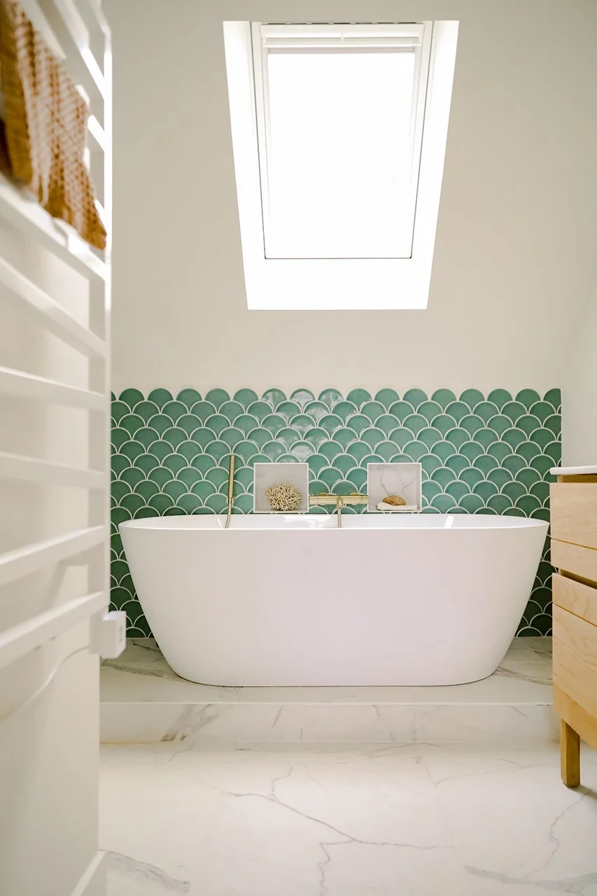 La douche et la baignoire sont sur une estrade en marbre, la faïence bleue en écaille de poisson fait ressortir la baignoire ilôt