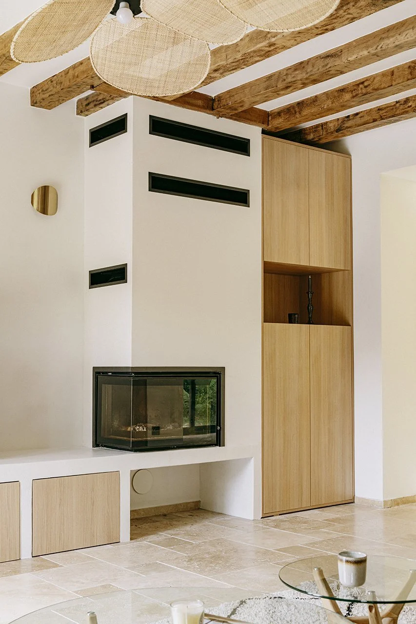 la cheminée est intégrée dans un ensemble maçonné qui se transforme en banc.