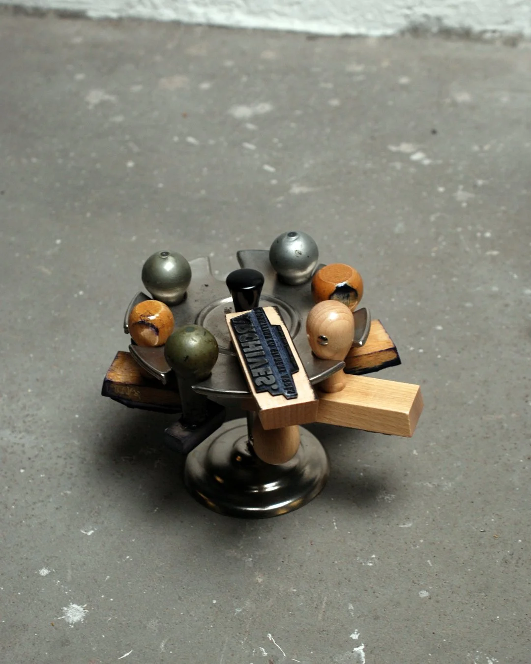 Un jeu de palets en métal et en bois, placé sur une surface en béton, avec des éléments en bois et en métal disposés autour.