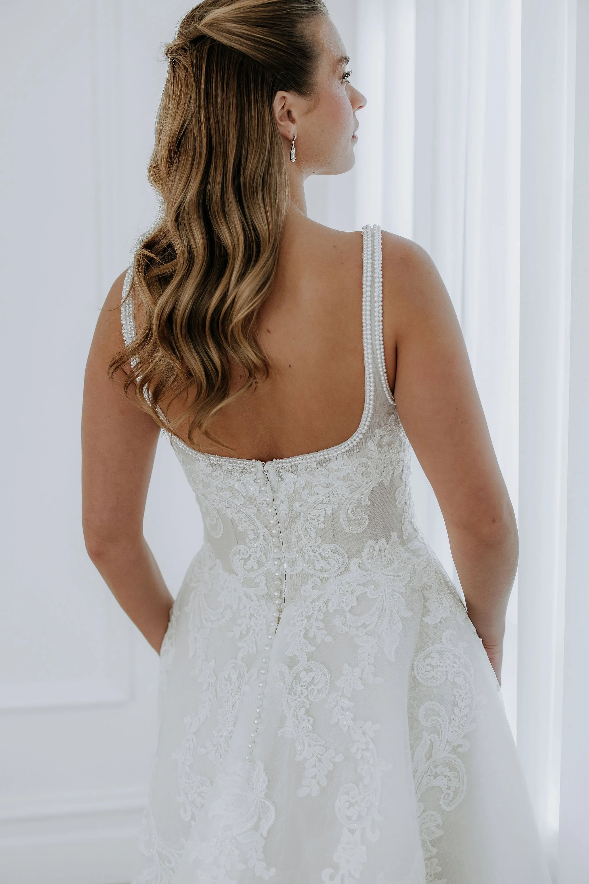 Back view of Ornella by Kelly Lin showing the Basque waist and pearl details on the straps. Available in Salisbury.