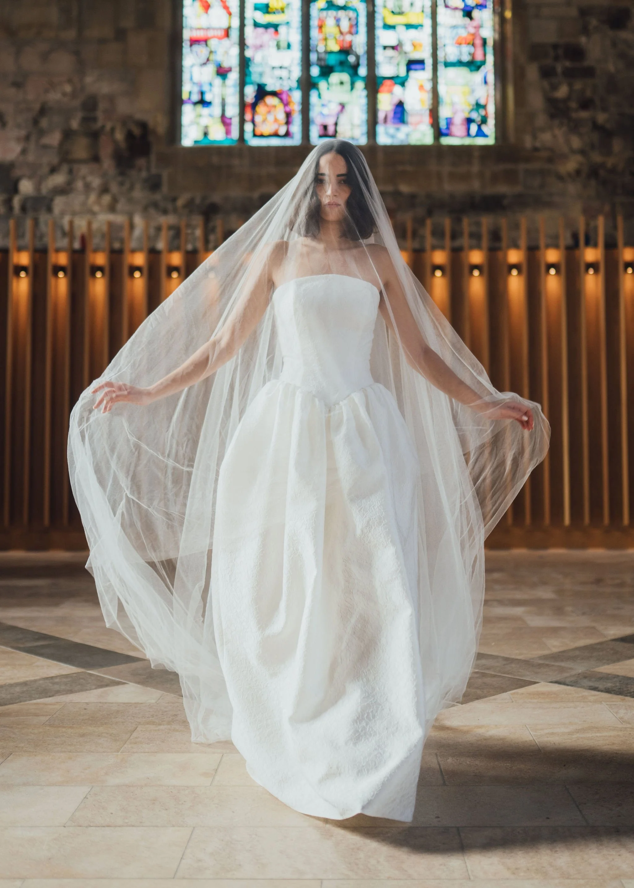 Titania Dress by Rolling in Roses – contemporary bridal gown inspired by Shakespeare's era, featuring a dropped waistline, sculptural tulip-shaped skirt with hidden pockets, and traditional corsetry techniques using high-quality sprung boning, crafte