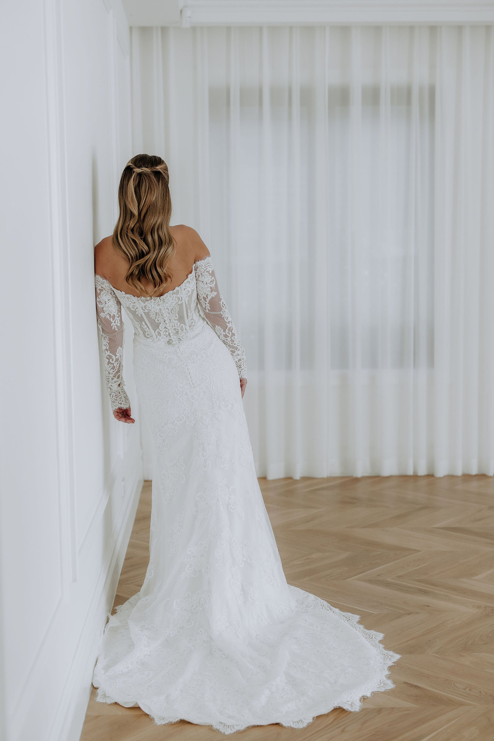 Kelly Lin's Mimi dress from her 2026 Whispers of Grace Collection. Full lace with a modern sheer bodice. Full length lace sleeves.