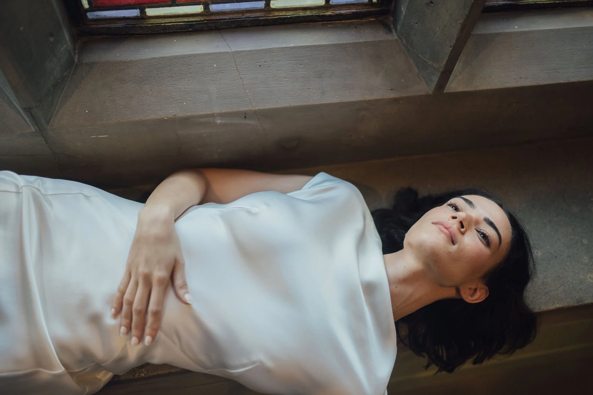 Beatrice Dress by Rolling in Roses – minimalist satin bridal gown with high cowl neckline, open back, angular darts, and detachable wrist loop, crafted from sustainable vegan satin and organic bamboo, available at Lyra Bridal Studio, UK