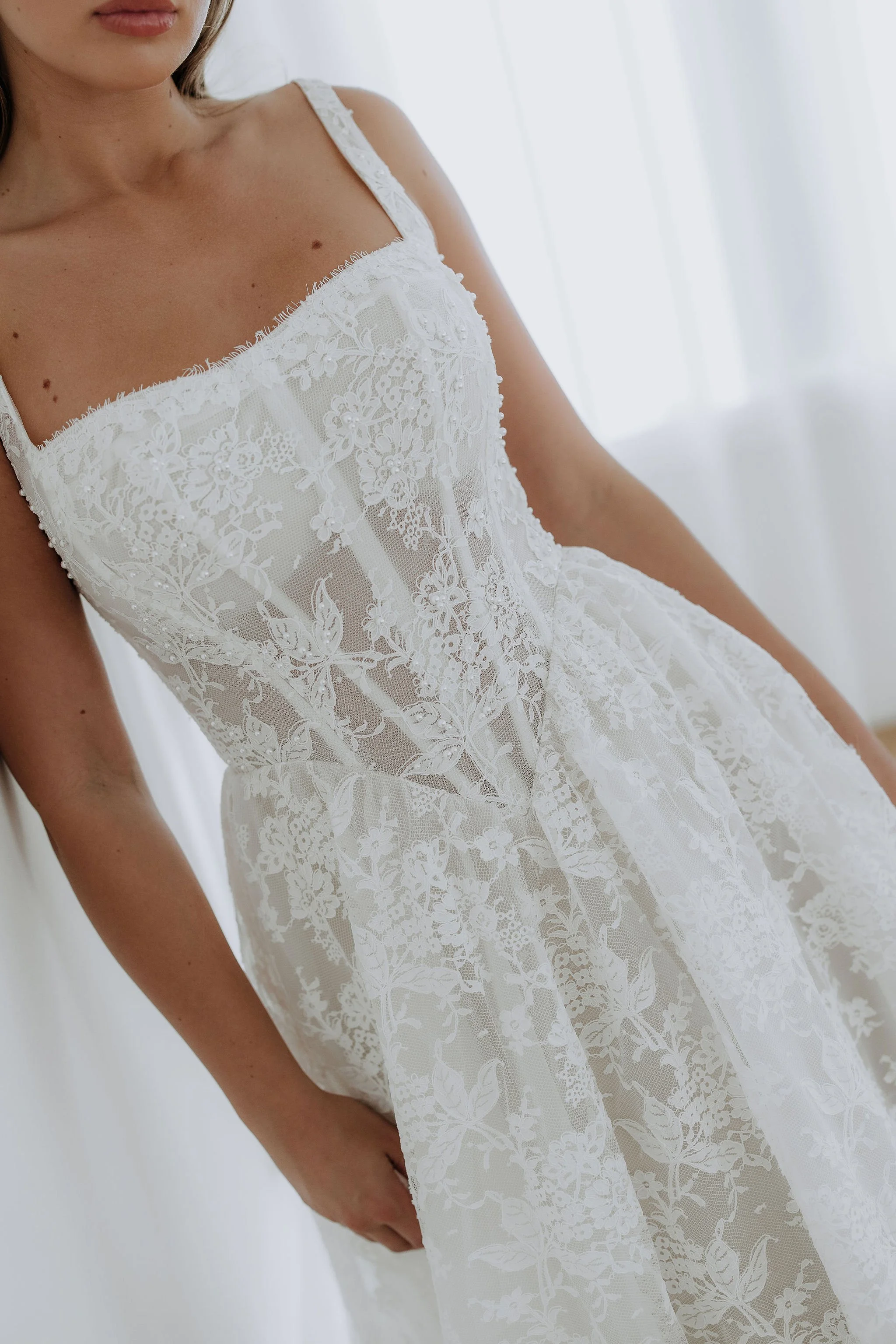 Close up of Kelly Lin's Elle dress. Showing the Basque waist and straps. Try on in our Salisbury wedding dress shop.