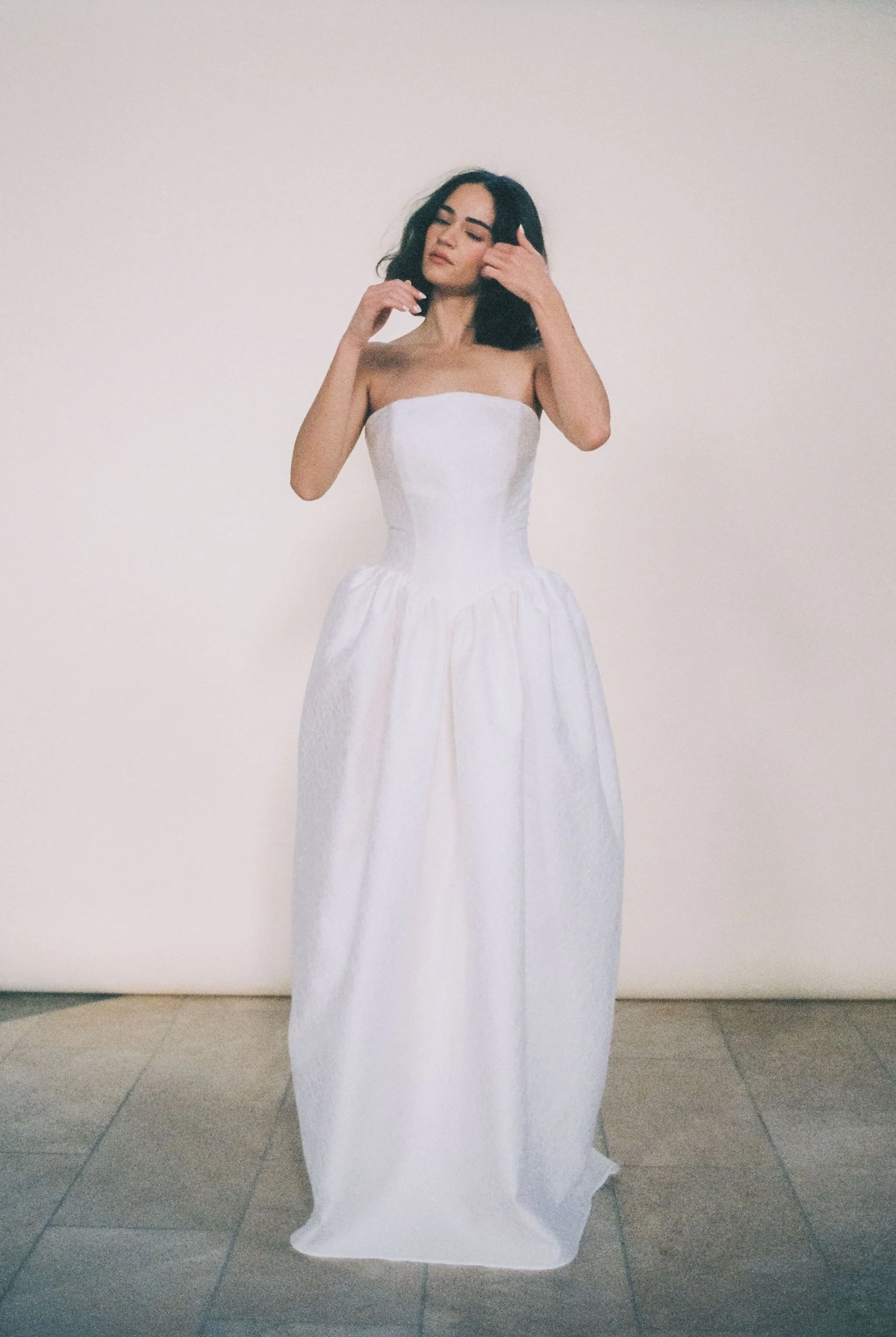 Titania Dress by Rolling in Roses – contemporary bridal gown inspired by Shakespeare's era, featuring a dropped waistline, sculptural tulip-shaped skirt with hidden pockets, and traditional corsetry techniques using high-quality sprung boning, crafte