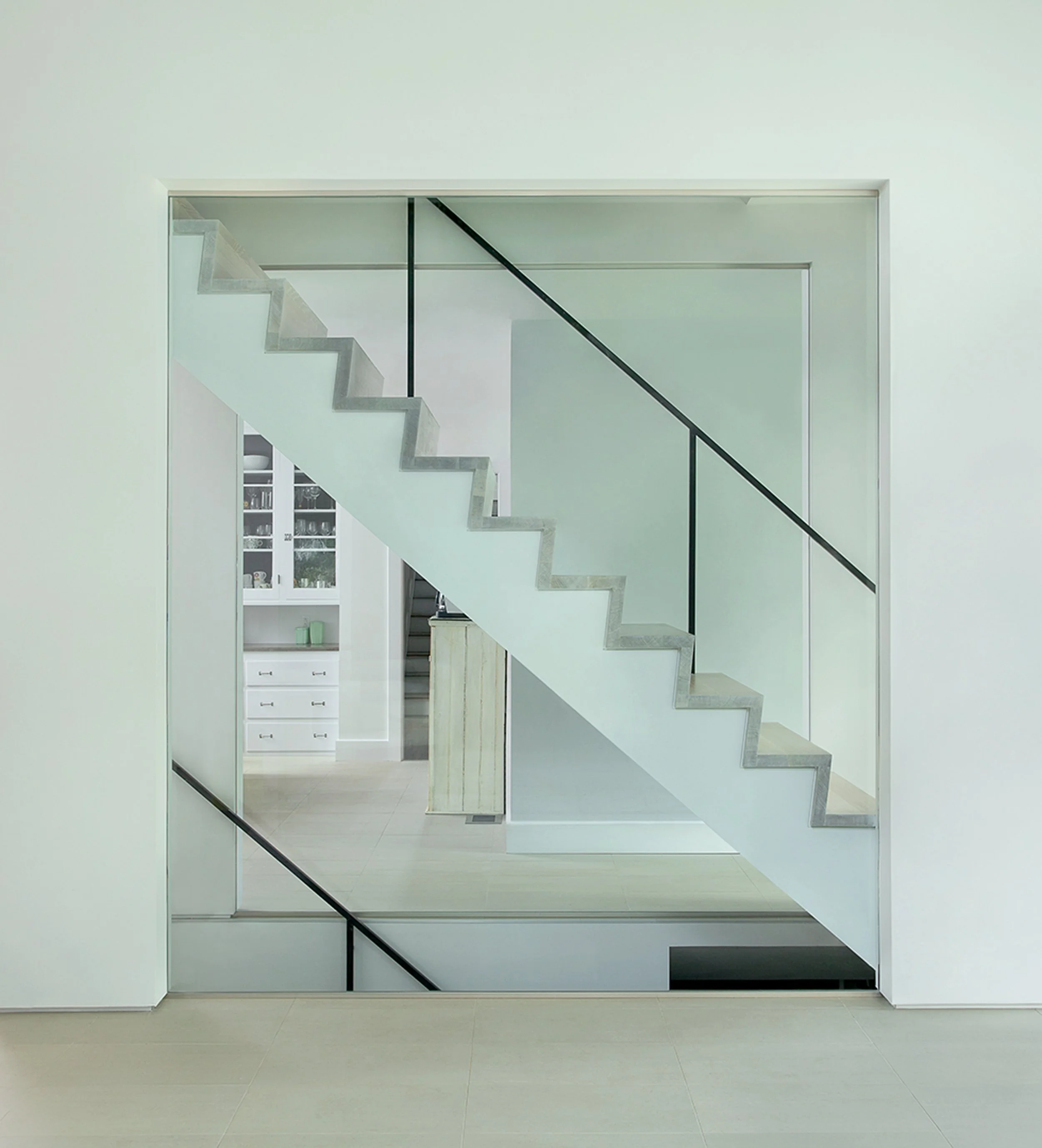 Floating concrete and glass staircase in luxury modern addition to traditional English stucco manor home renovation, Montclair New Jersey