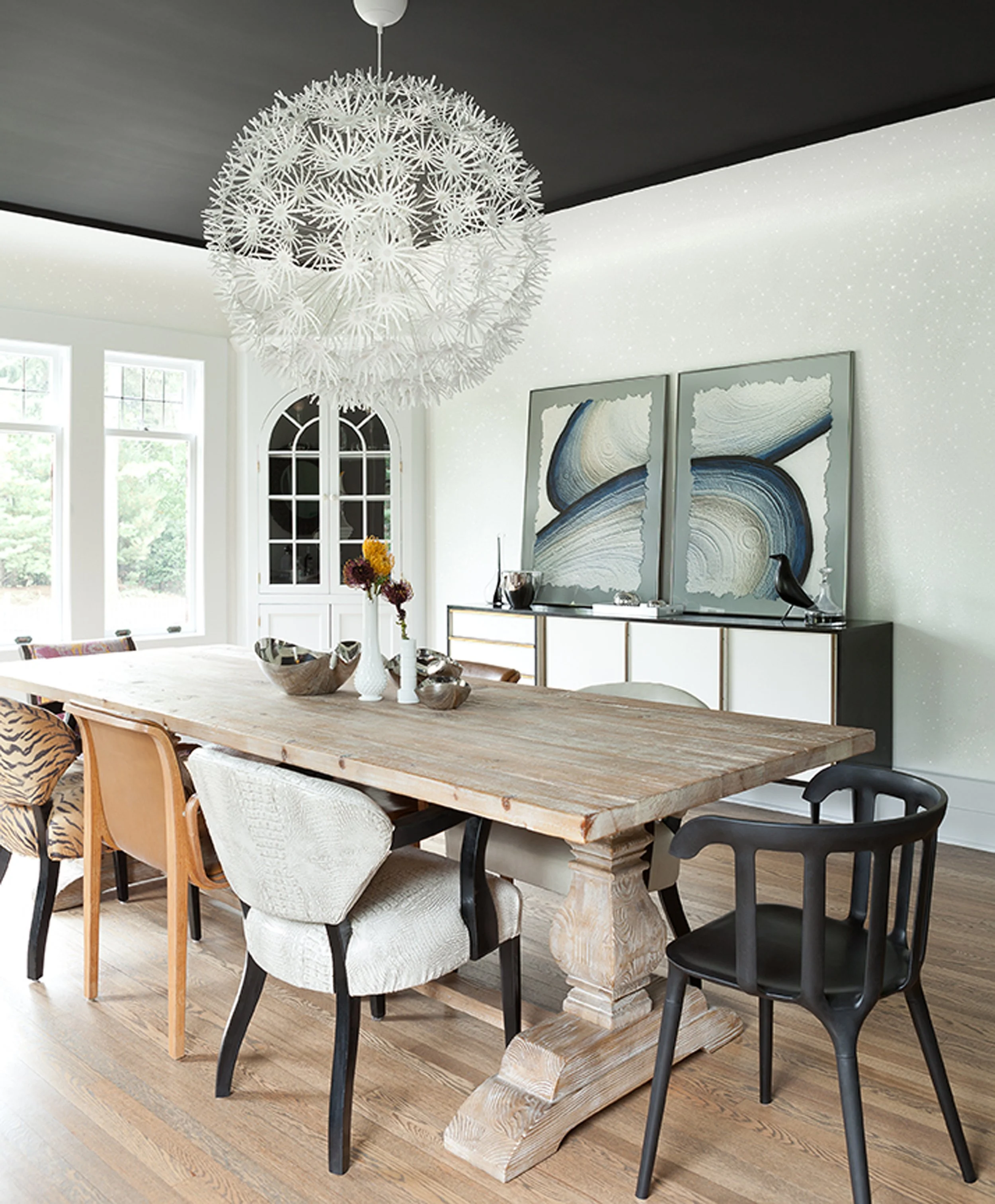 Luxury dining room renovation in traditional English stucco manor home with dramatic black painted ceiling, reclaimed wood trestle table, mixed eclectic dining chairs, and statement white sculptural chandelier — Montclair NJ