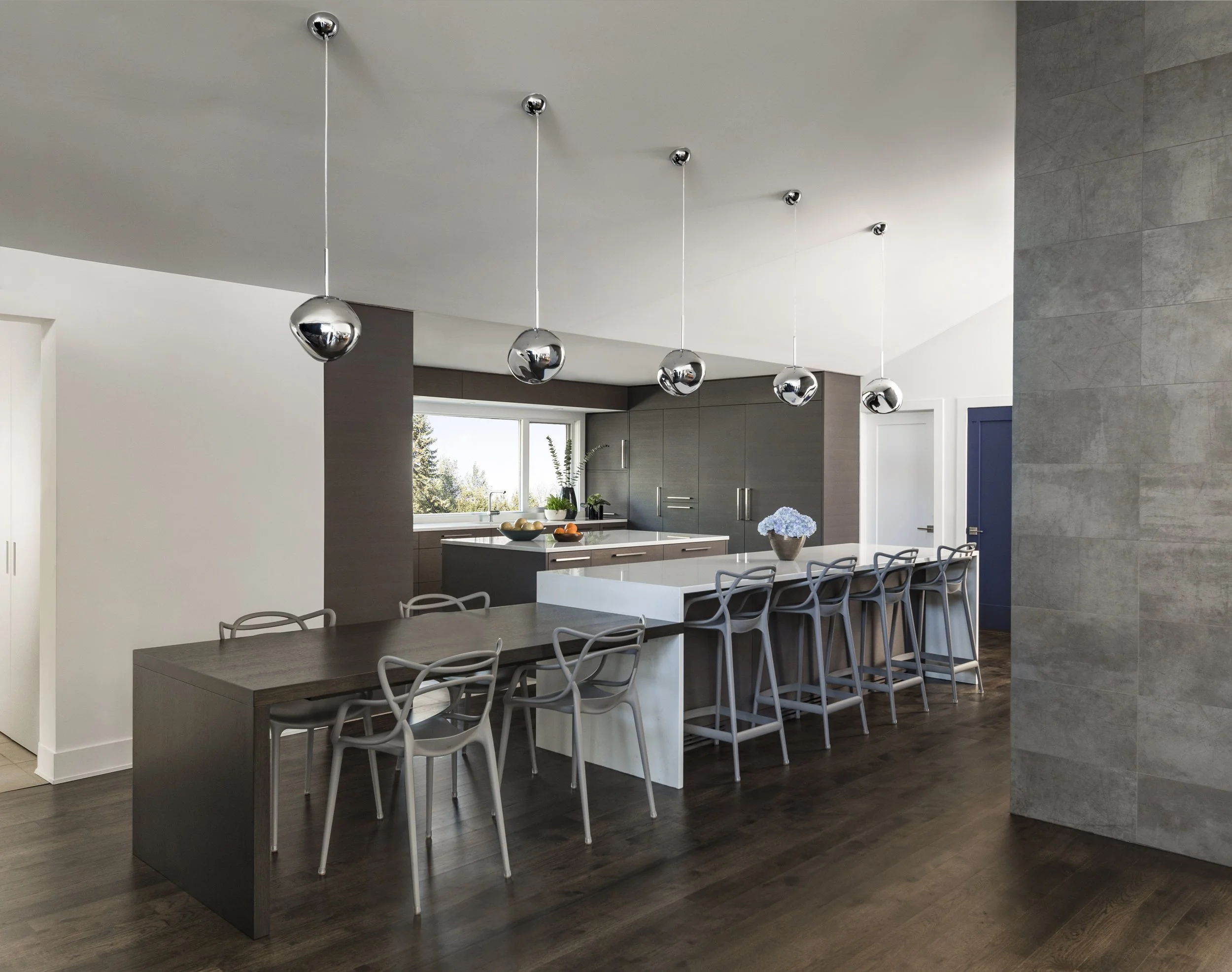 Luxury open-plan kitchen renovation featuring mirror-chrome globe pendants, quartz waterfall island, custom flat-panel cabinetry, and Kartell Masters barstools.