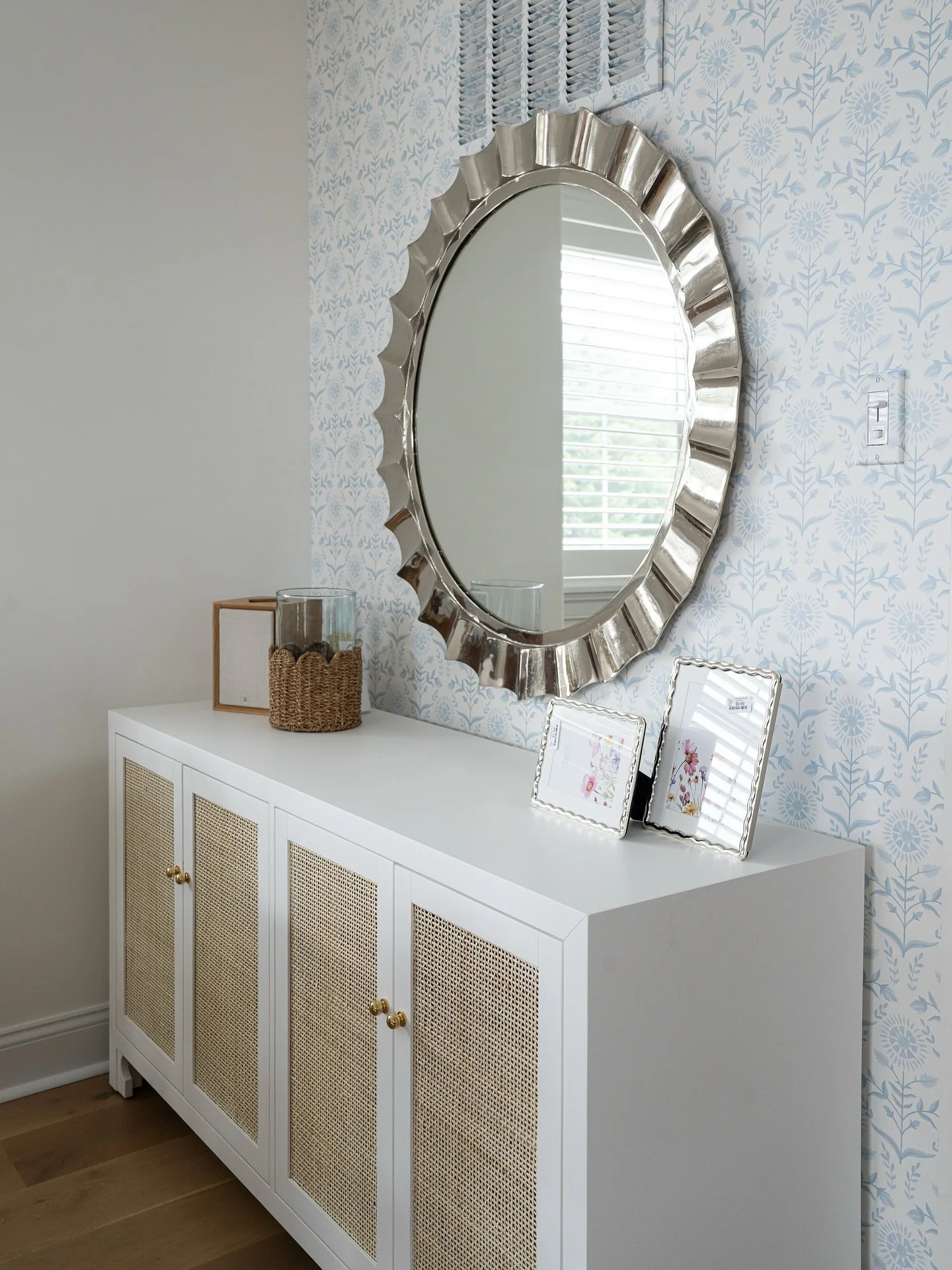 Layering pattern and texture adds depth without the clutter. We show you how to do this by balancing subtle wallpaper with natural textures (like the cane console) and a touch of shine from the mirror. It&rsquo;s a simple formula for major visual int