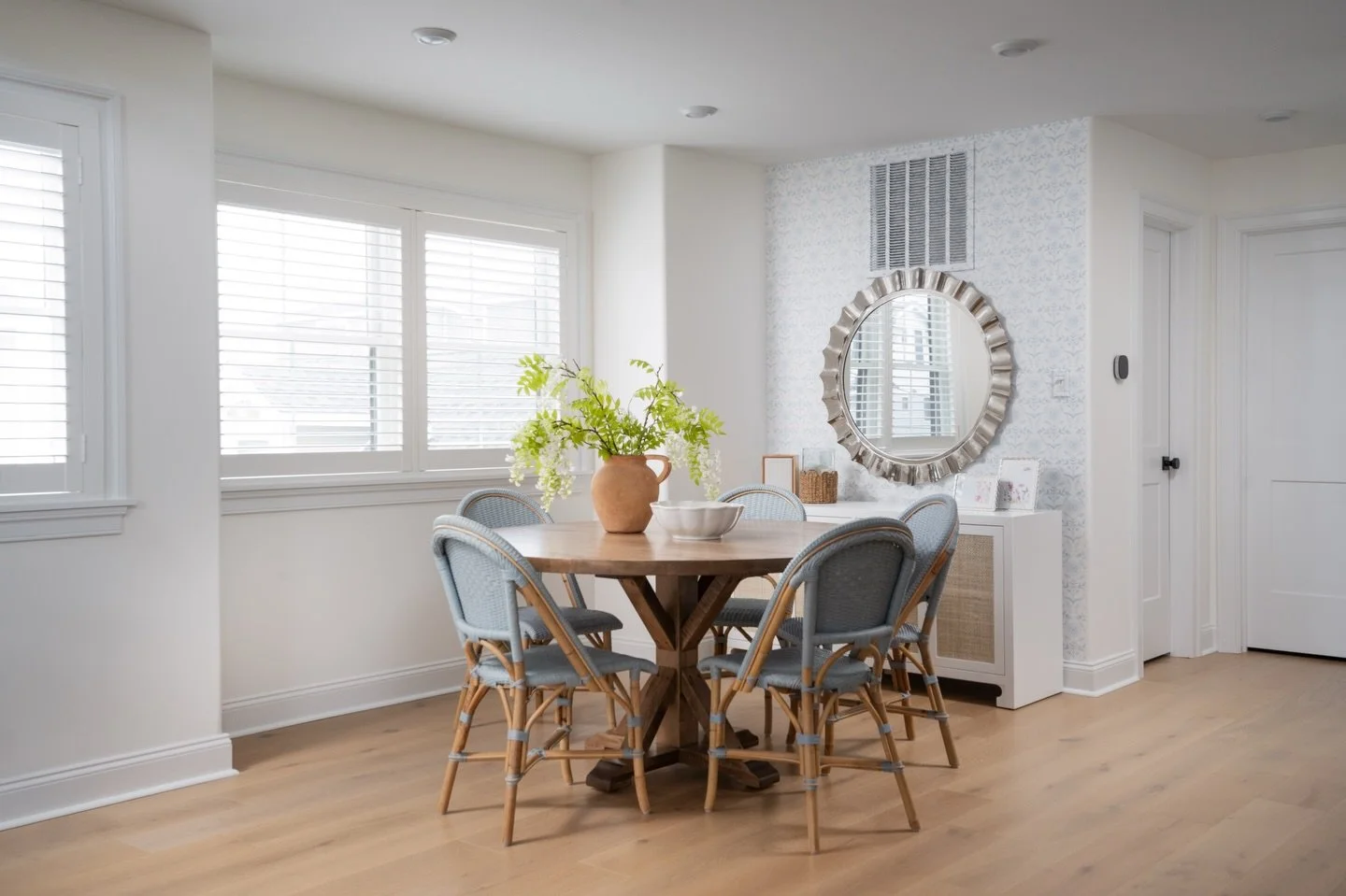 Dining chairs are a great place to introduce texture! Woven bistro chairs soften the harder surfaces in the room and add contrast next to the wood table and patterned wallpaper 🍽️

Design: @colorandcrownid 
Photography: @ommediallc 
Windows: @vitali