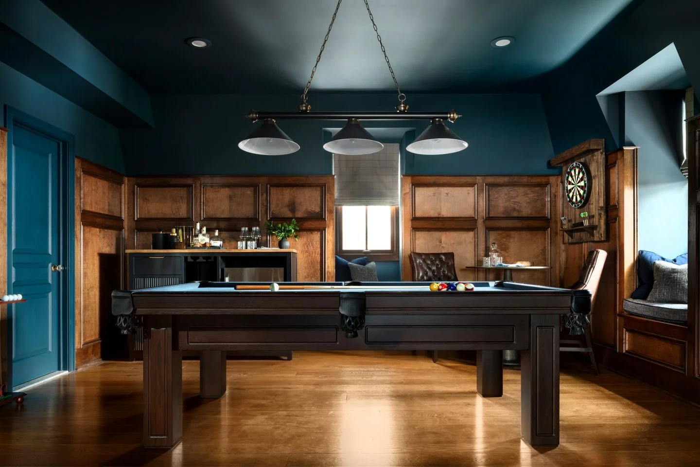 Bringing everyone together, this one was designed to make it easy to stay awhile. Deep blue walls and rich wood tones create the perfect atmosphere for late-night games. 🎱

Design: @colorandcrownid 
Photography: @ommediallc