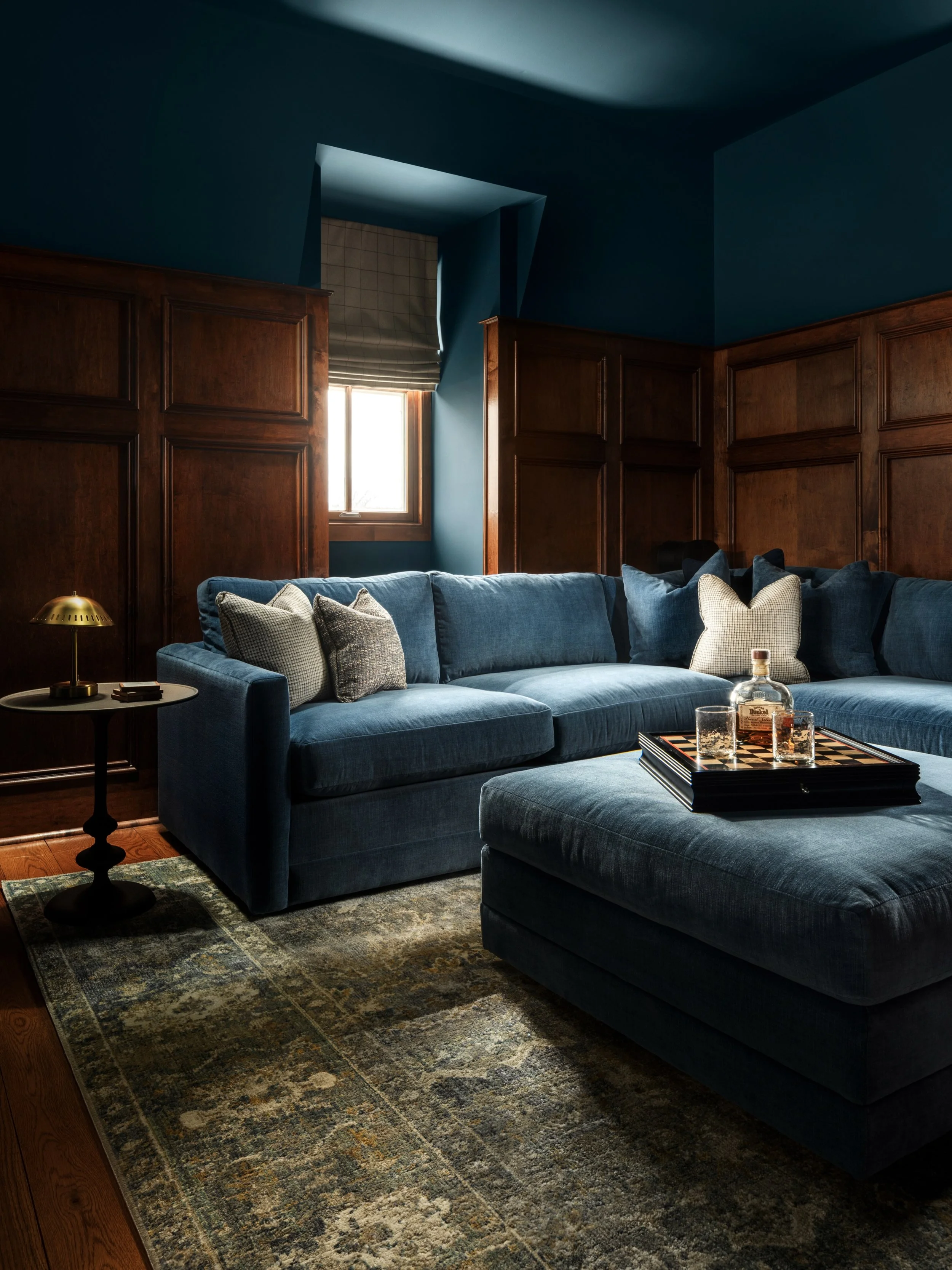 Sometimes all it takes is the right color. Instead of removing the existing wood paneling, we highlighted it with a deep blue that wraps the entire room, creating a dramatic transformation with just an intentional change 💙

Design: @colorandcrownid 