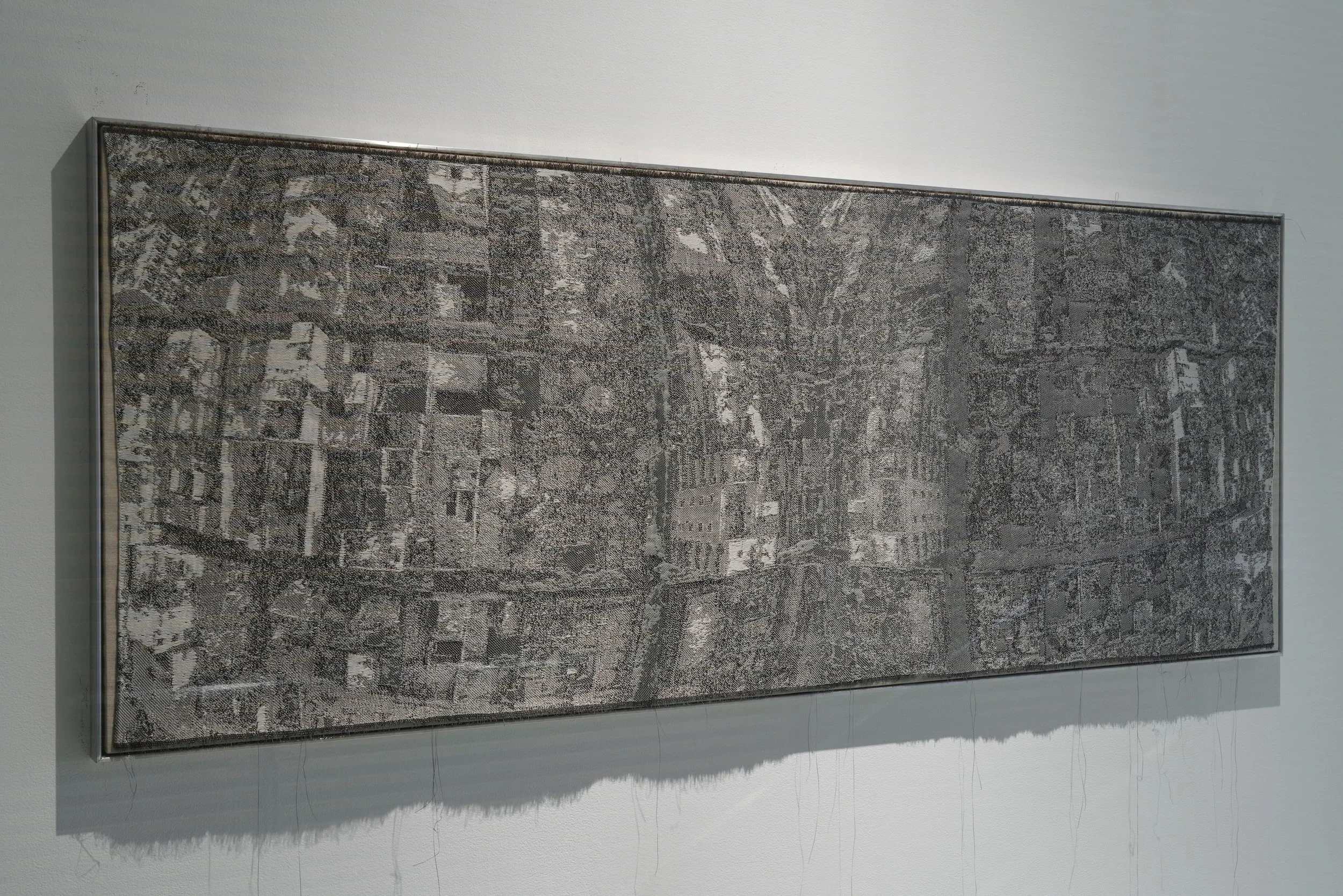 A framed black and white detailed city map hangs on a white wall.